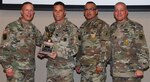Maj. Gen. Jeffrey J. Snow (left), commander, U.S. Army Recruiting Command, presents the U.S. Army 
Medical Recruiting Brigade’s “Top Recruiting Battalion of Excellence” award to (second from left) Lt. Col. Michael T. Peacock, 5th Medical Recruiting Brigade commander, and Command Sgt. Maj. Jesse Castellano Jr. (second from right). With them is U.S. Army Recruiting Command Sgt. Maj. Anthony T. Stoneburg (right).   
