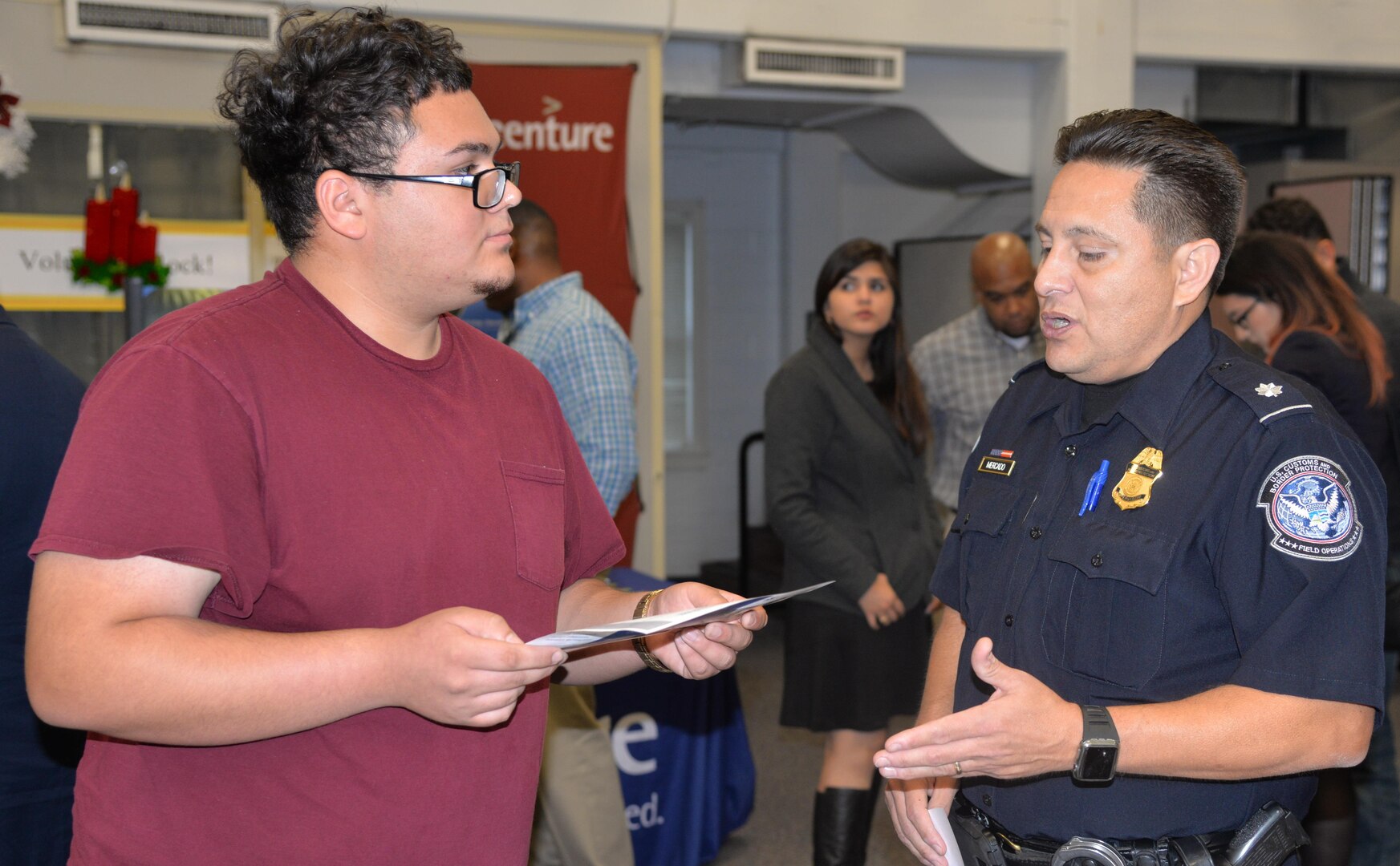 Supervisor Daniel Mercado (right), U.S. Customs and Border Protection field operations, talks to Joshua Martinez (left) about employment opportunities as a customs agent at the Hiring Our Heroes event  at the Joint Base San Antonio-Fort Sam Houston Military & Family Readiness Center Friday.