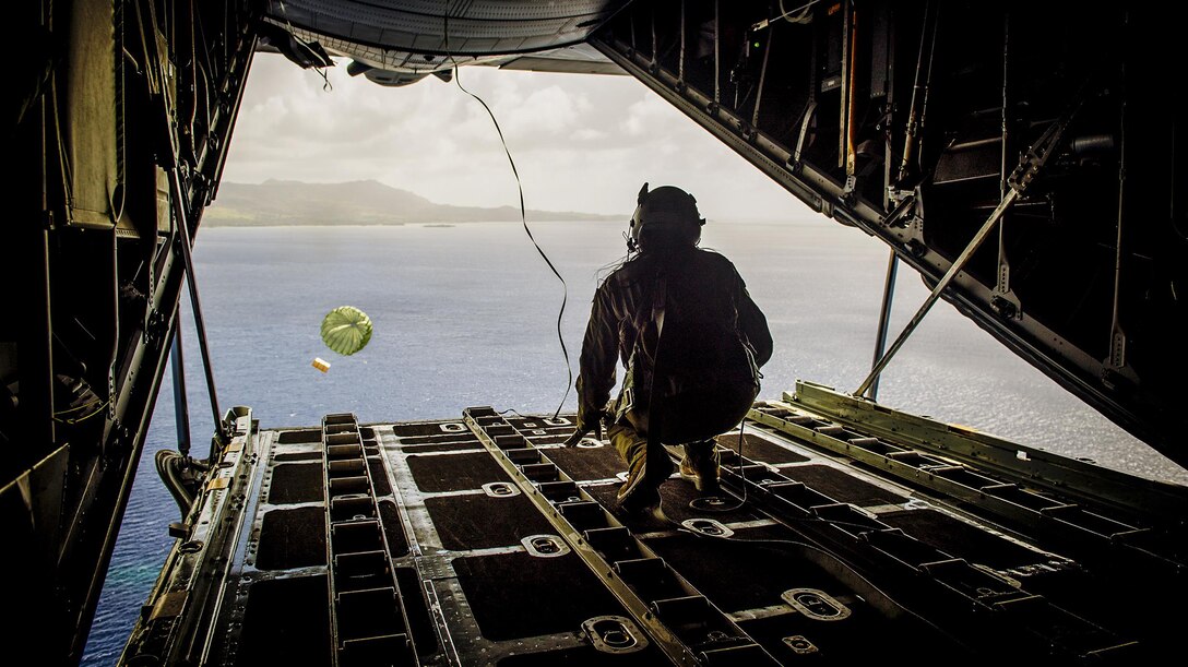 Airman 1st Class Alejandra Vargas, 36th Airlift Squadron C-130 Hercules loadmaster, pushes a bundle during Operation Christmas Drop at Andersen Air Force Base, Guam, Dec. 5, 2016. Australian and Japanese aircrews joined U.S. Airmen to execute the Humanitarian Aid/Disaster Relief training event where C-130 aircrews perform low-cost, low-altitude airdrops to drop zones while providing critical supplies to 56 islands.