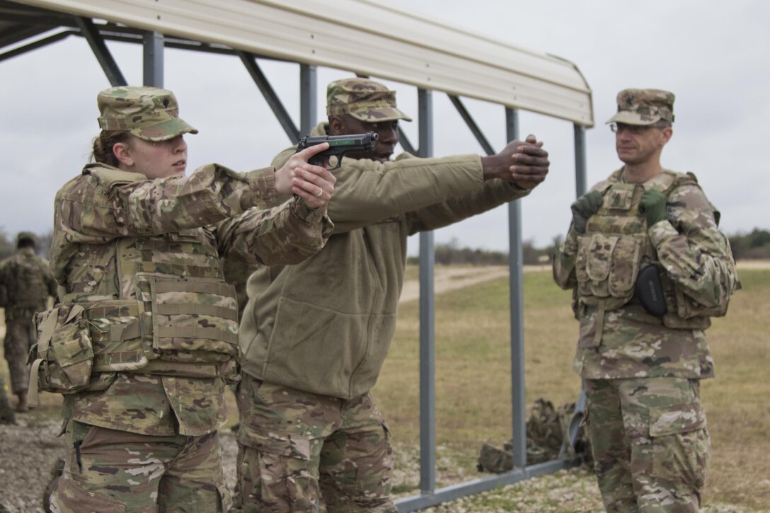 Chief Warrant Officer 3 Markell Green (middle) instructs Spc. Kylene Dodge (left), both Army Reserve Soldiers with the 316th Sustainment Command (Expeditionary), with a safety class on the M9 pistol before a qualification at Fort Hood, Tx., Dec. 5, 2016. (U.S. Army photo by Staff Sgt. Dalton Smith)