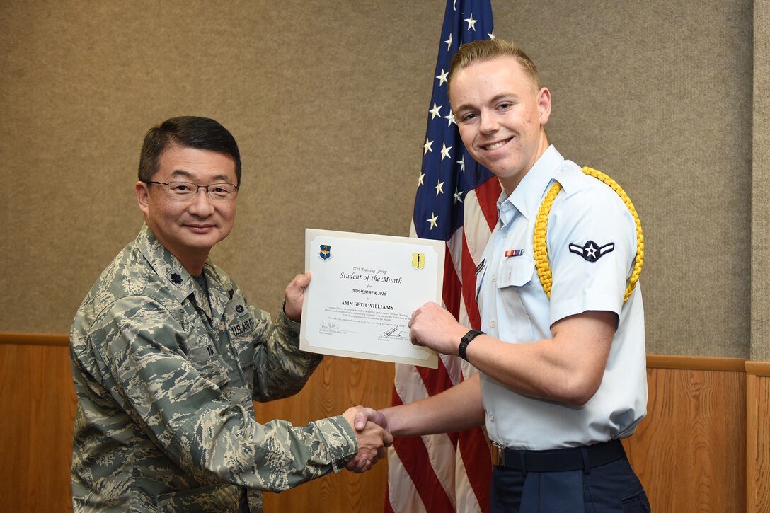 U.S. Air Force Lt. Col. Donald Yu, 17th Training Group Acting Commander, presents the 312th Training Squadron Student of the Month award for November 2016 to Airman Seth Williams at Brandenburg Hall on Goodfellow Air Force Base, Texas, Dec. 2, 2016. (U.S. Air Force photo by Airman 1st Class Chase Sousa/Released)