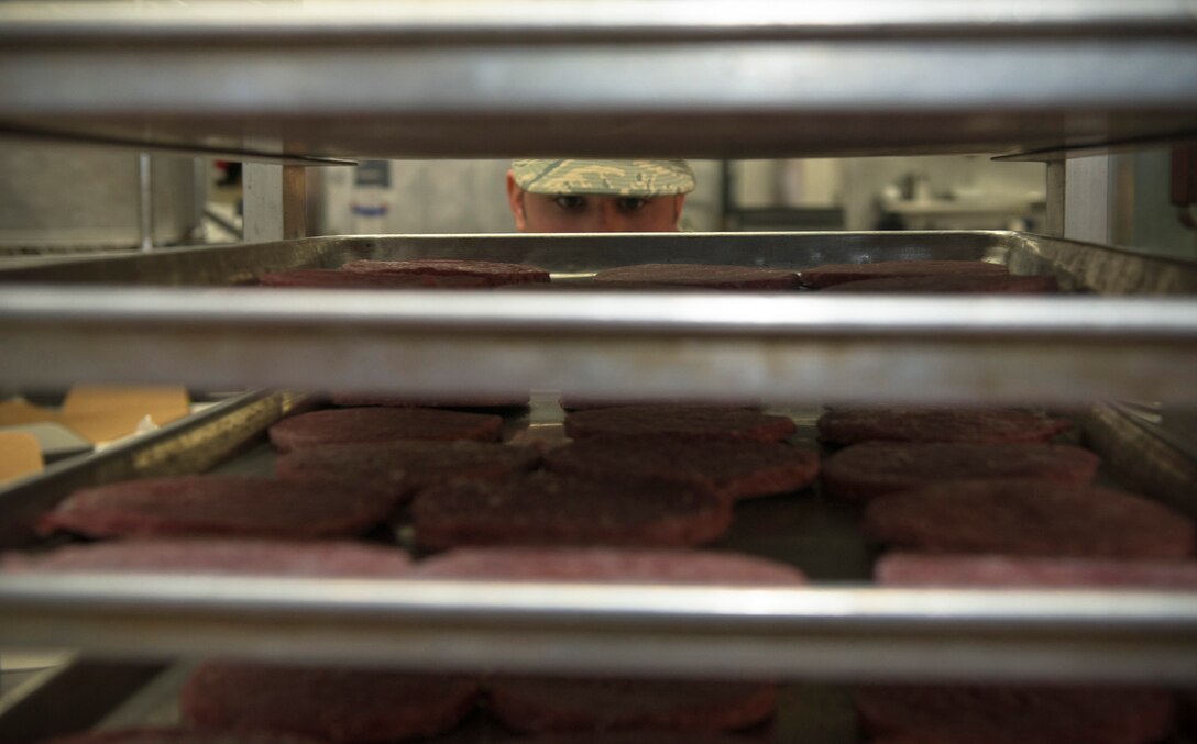 U.S. Air Force Senior Airman Steve Rodriguez, a services specialist with the 182nd Force Support Squadron, Illinois Air National Guard, prepares hamburgers at the December holiday meal in Peoria, Ill. Dec. 3, 2016. The squadron’s services flight creates special lunch menus to honor holidays occurring during the month. (U.S. Air National Guard photo by Tech. Sgt. Lealan Buehrer)