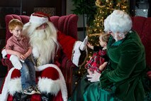 A child touches Santa’s hand while being held by Mrs. Claus at the Holiday Party and Tree Lighting at Scott Air Force Base, Ill., Nov. 30, 2016. During the party, children had the opportunity to meet Santa and Mrs. Claus, listen to the Band of Mid-America, drink holiday refreshments and create crafts. (U.S. Air Force photo by Senior Airman Megan Friedl)