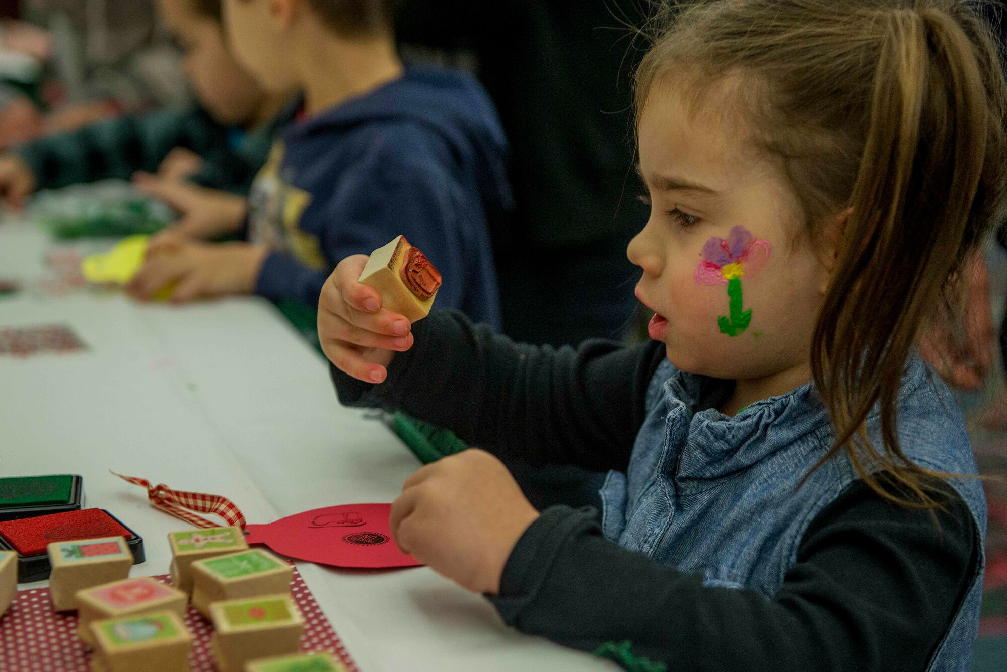 A child looks at a stamp that she’s using to create an ornament at the Holiday Party and Tree Lighting at Scott Air Force Base, Ill., Nov. 30, 2016. Children created many holiday crafts and trinkets during the party. (U.S. Air Force photo by Senior Airman Josh Eikren)
