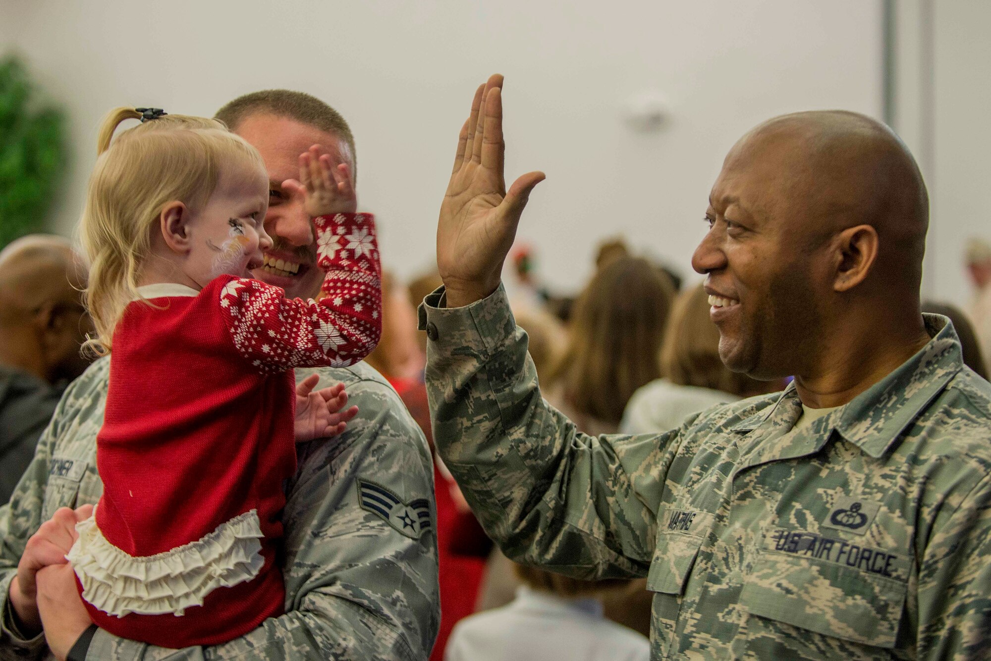 Chief Master Sgt. Wes Mathias, 375th Air Mobility Wing Command chief, high fives a young girl at Scott Air Force Base, Ill., Nov. 30, 2016. Mathias met with many Airmen and their families during the party. (U.S. Air Force photo by Senior Airman Josh Eikren)