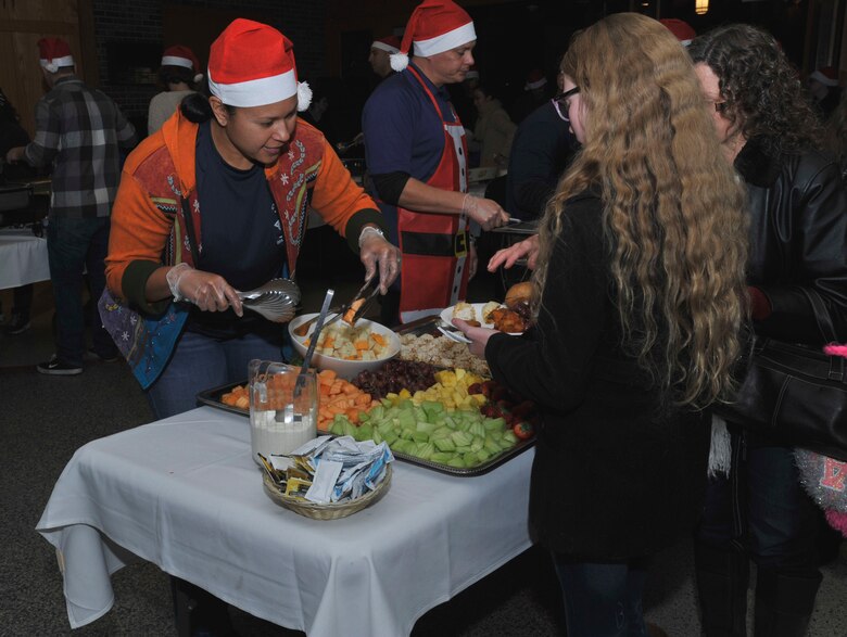 PETERSON AIR FORCE BASE, Colo. – Master Sgt. Jenet Shaffner, 561st Network Operations Squadron, serves food to members of Team Pete at the 21st Space Wing Holiday Tree Lighting Ceremony at the Peterson chapel, Dec. 2, 2016, at Peterson Air Force Base, Colo. The yearly event is hosted by the chapel offering family arts and crafts activities and food catered by The Club to kick-off the holiday season.  (U.S. Air Force photo by Alethea Smock)