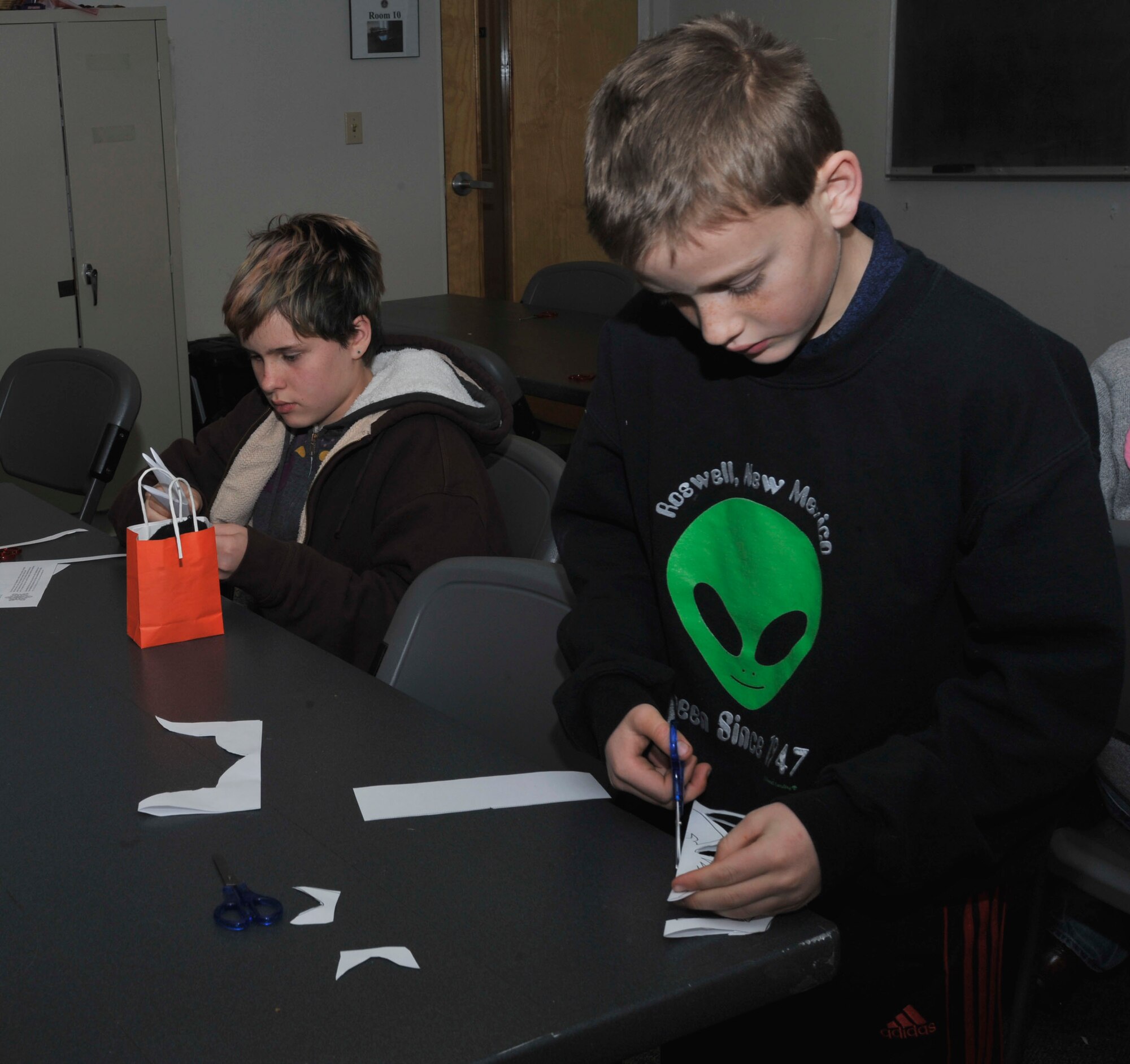 PETERSON AIR FORCE BASE, Colo. – Members of Team Pete families make snowflakes during the 21st Space Wing Holiday Tree Lighting Ceremony at the Peterson chapel, Dec. 2, 2016 at Peterson Air Force Base, Colo. The yearly event is hosted by the chapel offering family arts and crafts activities and food catered by The Club to kick-off the holiday season.  (U.S. Air Force photo by Alethea Smock)