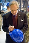 Sen. Tom Carper, D-Del., autographs a hard hat at the end of his C-5 Isochronal Inspection Dock tour Nov. 28, 2016, at Dover Air Force Base, Del. Distinguished visitors to the ISO Dock are asked to sign the hard hat they wore during their tour as it will be placed in a glass case across from the ISO Dock Coordinator’s Office, making Carper’s hard hat the ninth one on display. (U.S. Air Force photo by Roland Balik)