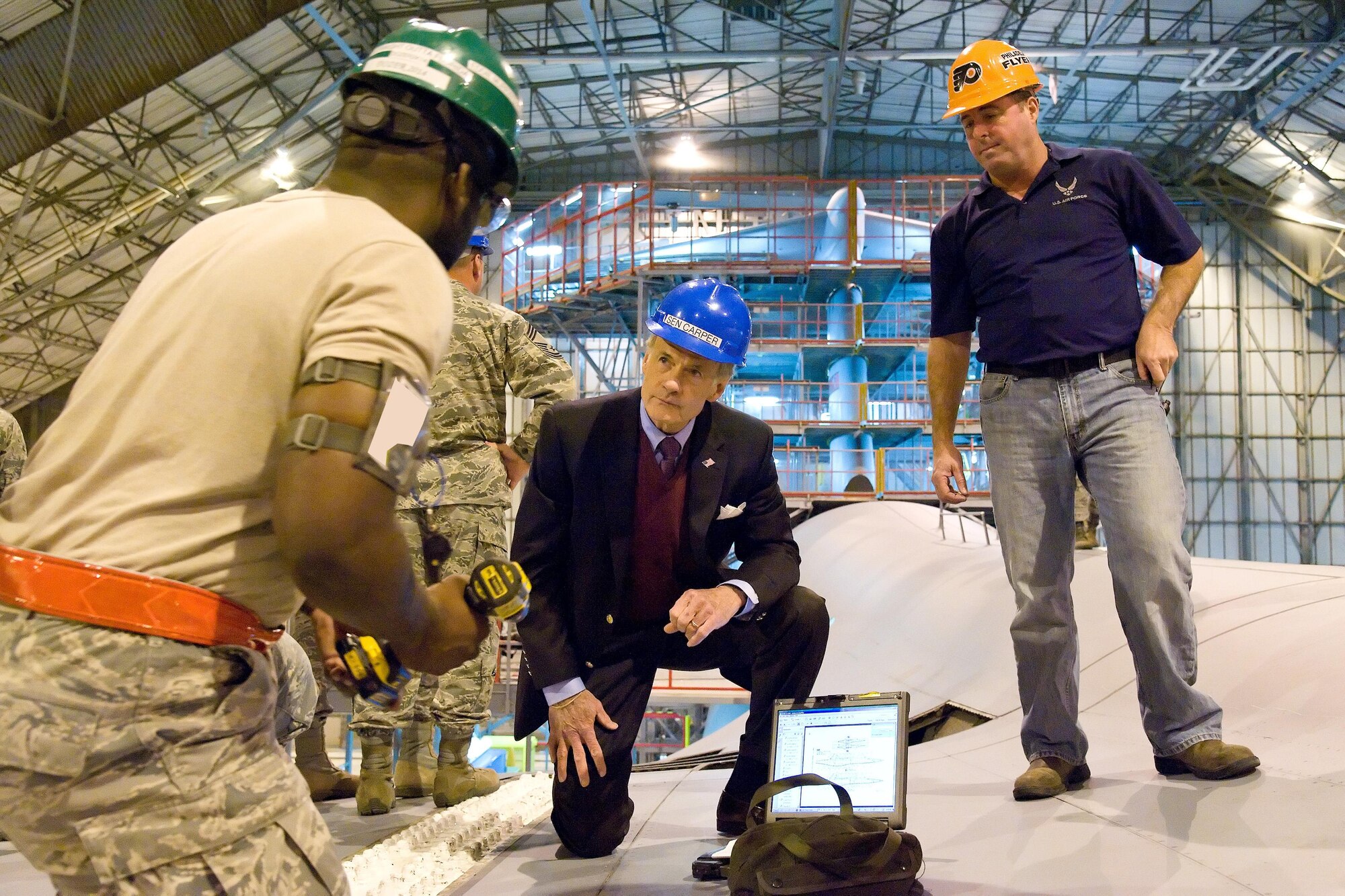 Senior Airman Akeem Beazer, 436th Maintenance Squadron aerospace maintenance journeyman, explains to Sen. Tom Carper, D-Del., what maintenance task he is performing on top of a C-5B Galaxy Nov. 28, 2016, in the C-5 Isochronal Inspection Dock on Dover Air Force Base, Del. John Greim, 436th MXS Isochronal Inspection Dock coordinator, observed Beazer as he demonstrated the removal of the right wing splice bolt panel, a task listed in the inspection work cards. (U.S. Air Force photo by Roland Balik)