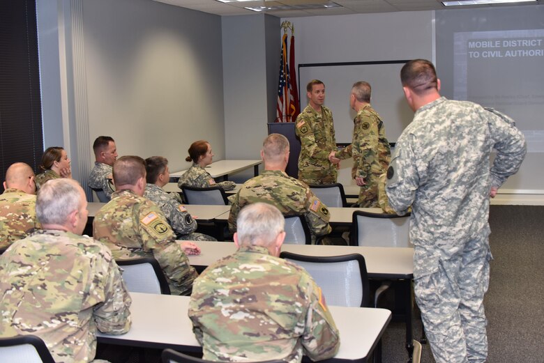 U.S. Army Corps of Engineers Mobile District Commander Col. James DeLapp shakes hands with Col. Alan Craig Cranford, from the National Guard Joint Force Headquarters-Alabama (JFHA) during combined emergency management training between JFHA and USACE Mobile. National Guard units from the district and USACE Mobile often work together to cross-train emergency response protocols and to strengthen readiness and interoperability across both formations.