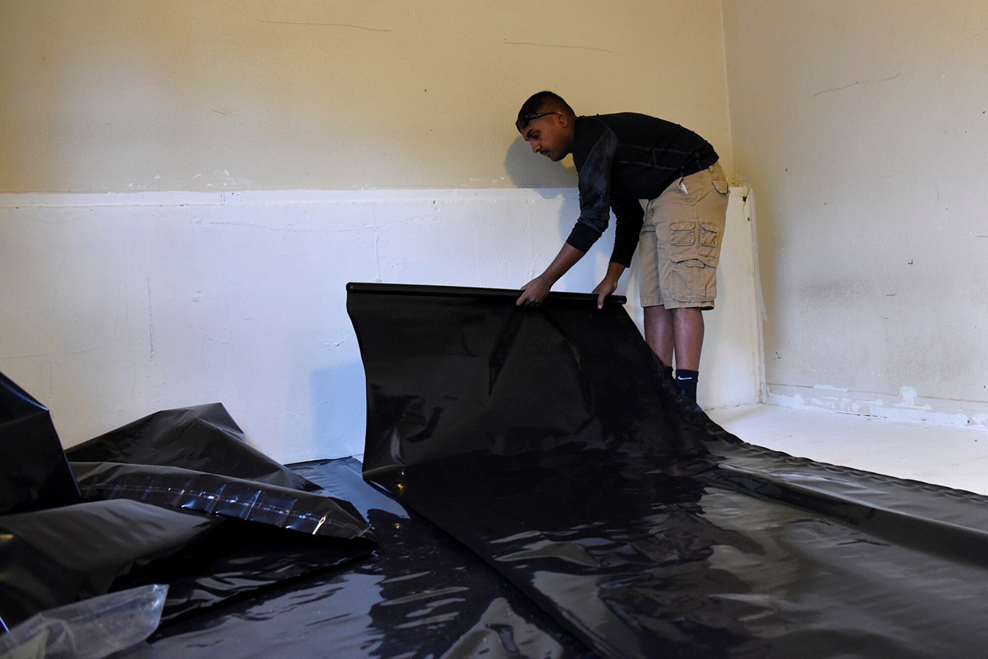 COLORADO SPRINGS, Colo. – Senior Airman Dillan Chatar, 21st Civil Engineer Squadron structures shop at Peterson Air Force Base, Colo., lays plastic down to protect the floor from moisture before laying down flooring in Colorado Springs, Nov. 5, 2016. Volunteers from Peterson AFB installed flooring in a fellow wingman’s house to meet medical needs of their spouse so they could come home from the hospital. (U.S. Air Force photo by Senior Airman Rose Gudex)