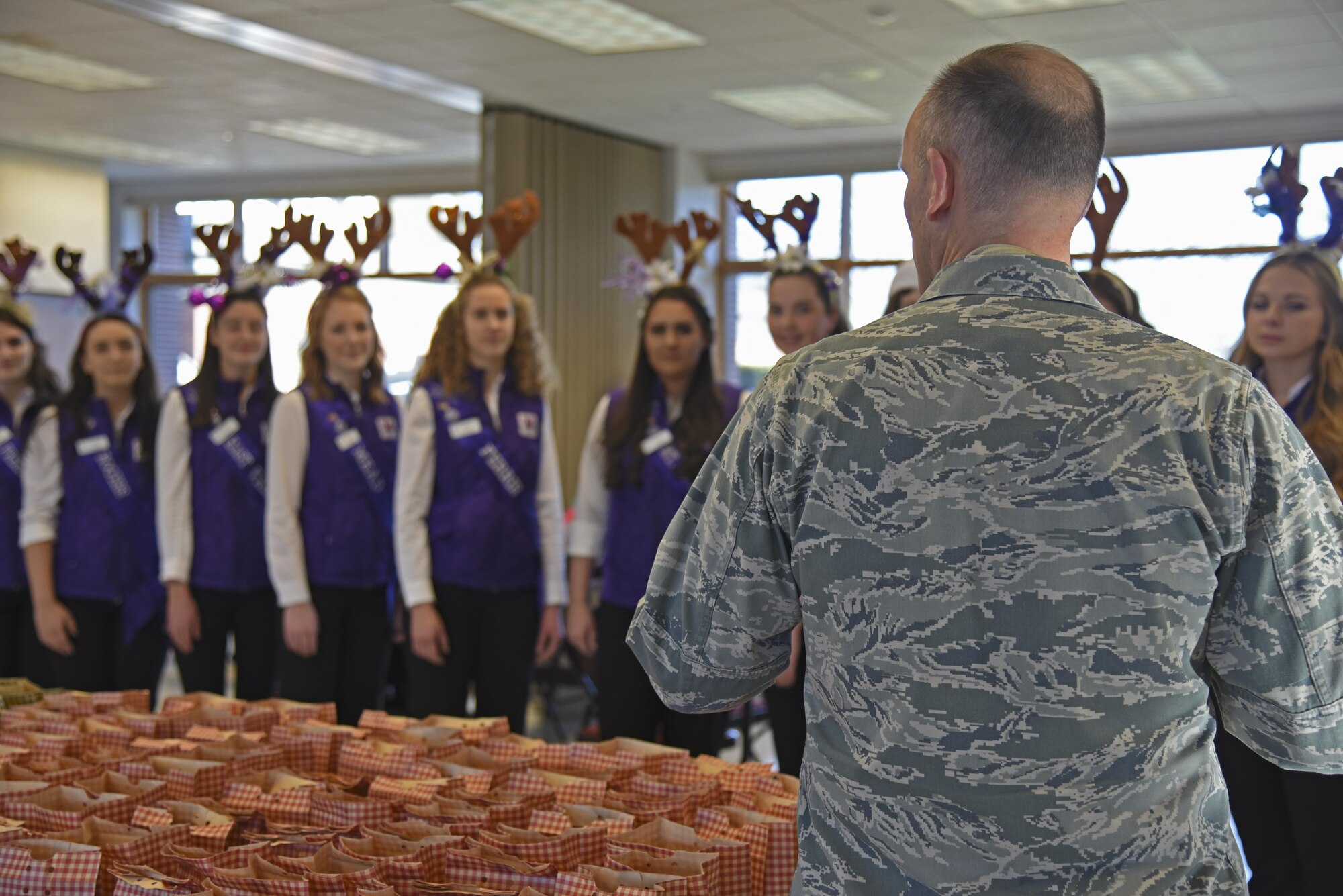 Col. Ryan Samuelson, 92nd Air Refueling Wing commander, speaks with 14 Spokane Lilac Festival Princesses during the annual Operation Cookie Drop Dec. 6, 2016, at Fairchild Air Force Base. The Lilac Princesses were joined by the Officer’s Spouses Club in packing more than 500 bags for Airmen living in the dormitories. (U.S. Air Force photo/Senior Airman Mackenzie Richardson)