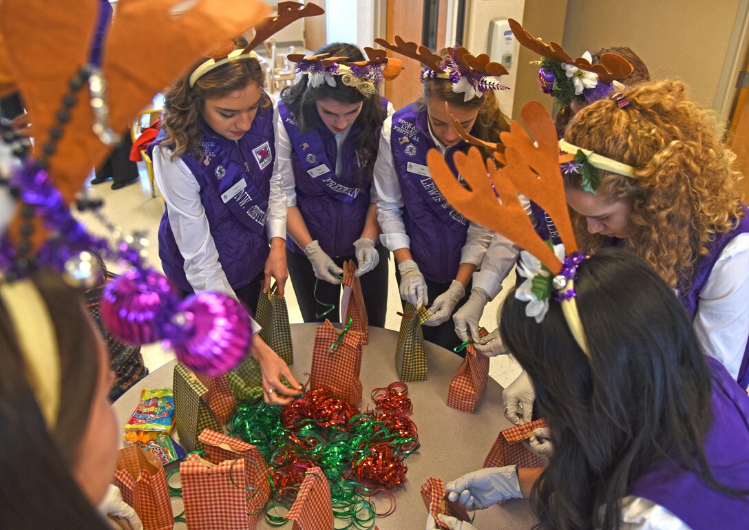 Spokane Lilac Festival Princesses put the finishing touches on bags full of cookies during the annual Operation Cookie Drop Dec. 6, 2016, at Fairchild Air Force Base. The Officer’s Spouses Club hosted the event and baked nearly 550 dozen cookies for Airmen living in the dormitories. (U.S. Air Force photo/Senior Airman Mackenzie Richardson)
