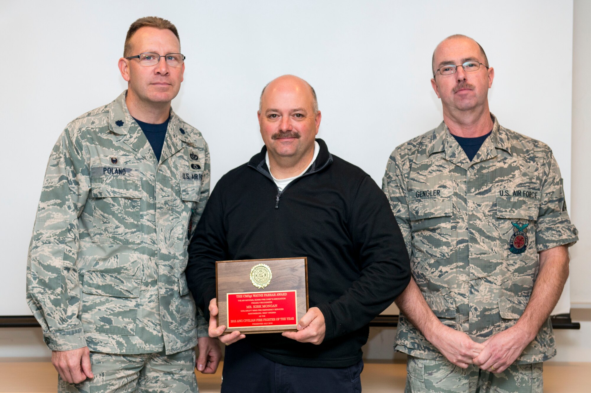 Lt. Col. John Poland (left), the civil engineering squadron commander at the 167th Airlift Wing in Martinsburg, W.Va., and Chief Master Sgt. Jeffery Gengler (right), fire chief at the 167th, recognize Kirk Mongan (middle), assistant chief of operations at the 167th AW Fire Emergency Services, as 2015 Air National Guard Civilian Firefighter of the Year, Dec. 2, 2016. Mongan was chosen from all of the civilian Air National Guard Firefighters by the Air National Guard Fire Chiefs Association. (Air National Guard photo by Staff Sgt. Jodie Witmer) 