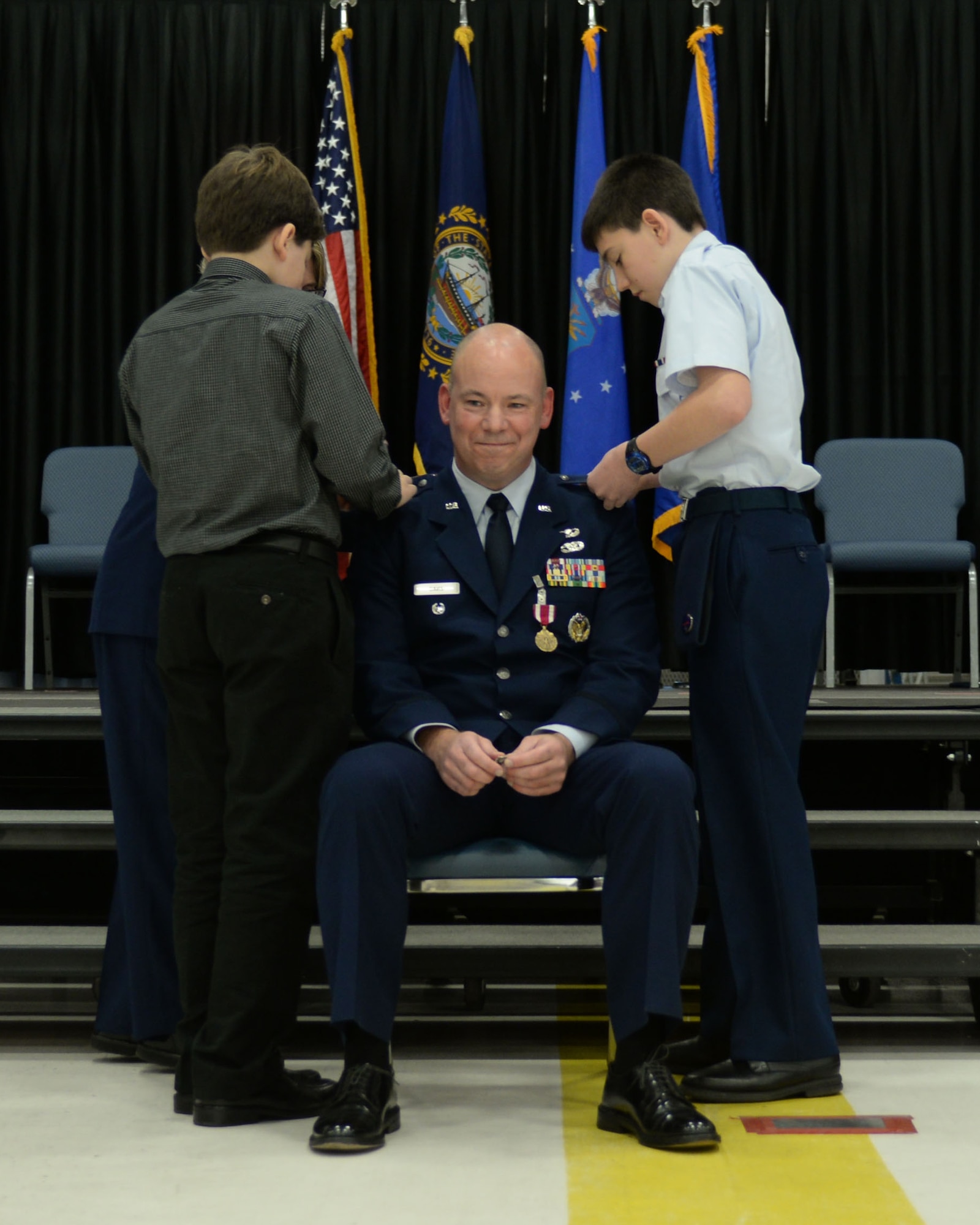 Family friends of Col. William Davis, 157th Air Refueling Wing vice commander, Mr. Tyler Denton and Civil Air Patrol Cadet Airman 1st Class Nicholas Denton pin new rank to his uniform during his promotion ceremony at Pease Air National Guard Base, N.H., Dec. 3, 2016. (U.S. Air National Guard photo by Staff Sgt. Kayla Rorick)