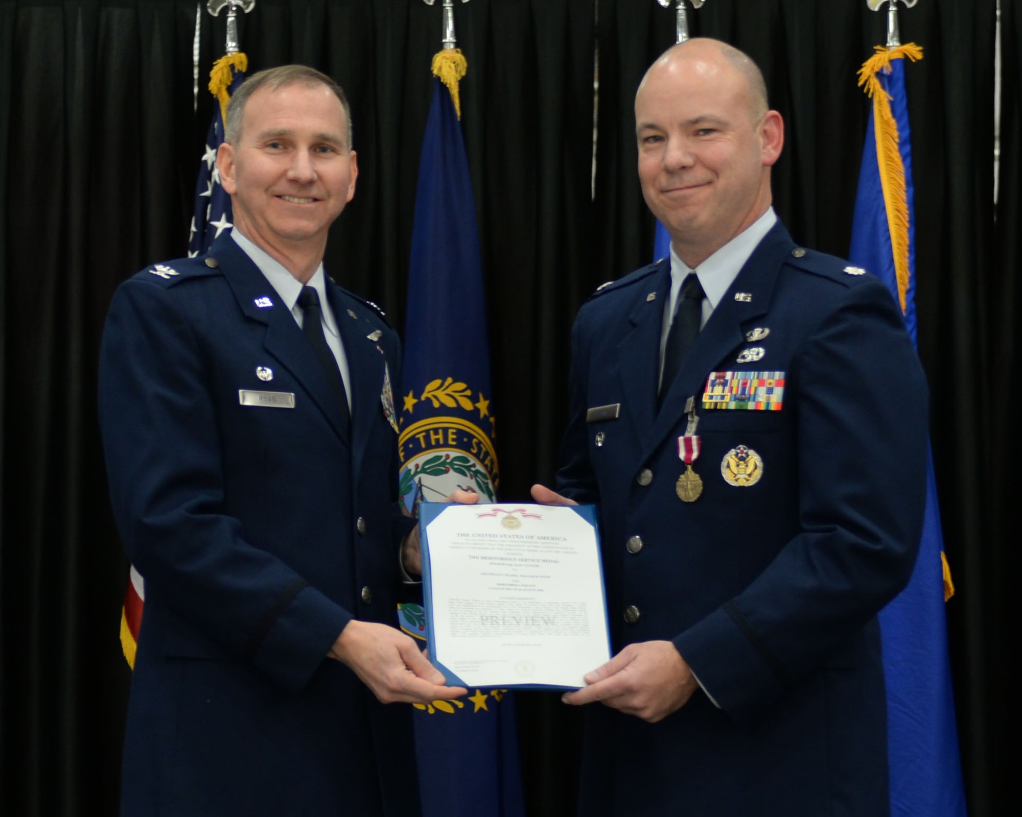 Lt. Col. William Davis, right, 157th Air Refueling Wing vice commander, is presented the Meritorious Service medal and certificate by Col. James Ryan, 157 ARW commander, during a promotion ceremony at Pease Air National Guard Base, N.H., Dec. 3, 2016. During the ceremony, Davis was promoted to colonel. (U.S. Air National Guard photo by Staff Sgt. Kayla Rorick)