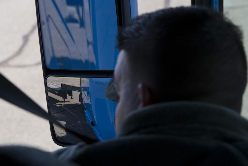 Senior Airman Antonio Chaviano, 436th Logistics Readiness Squadron vehicle operations central dispatcher, checks his mirror as he backs a 40-foot-long trailer between cones in a 90 degree turn during the ground transportation rodeo Dec. 2, 2016, at Dover Air Force Base, Del. To complete the course, Airmen had to weave between cones with both a forklift and tractor trailer and back the trailer between cones perpendicular to the obstacle course. (U.S. Air Force photo by Senior Airman Aaron J. Jenne)