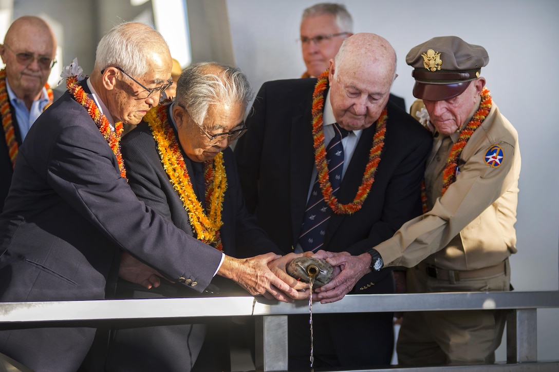 Left to right: Shiro Wakita, former World War II Japanese navy pilot; Dr. Hiroya Sugano, director general of the Zero Fighter Admirers Club; Jack Detour, former colonel and World War II Army Air Force B-25 pilot; and Jerry Yellin, former captain and World War II Army Air Force P-51 pilot, pour bourbon whiskey at the 6th annual Blackened Canteen ceremony at the USS Arizona Memorial during the 75th commemoration of the attacks on Pearl Harbor, Hawaii, Dec. 6, 2016. Navy photo by Petty Officer 2nd Class Somers Steelman