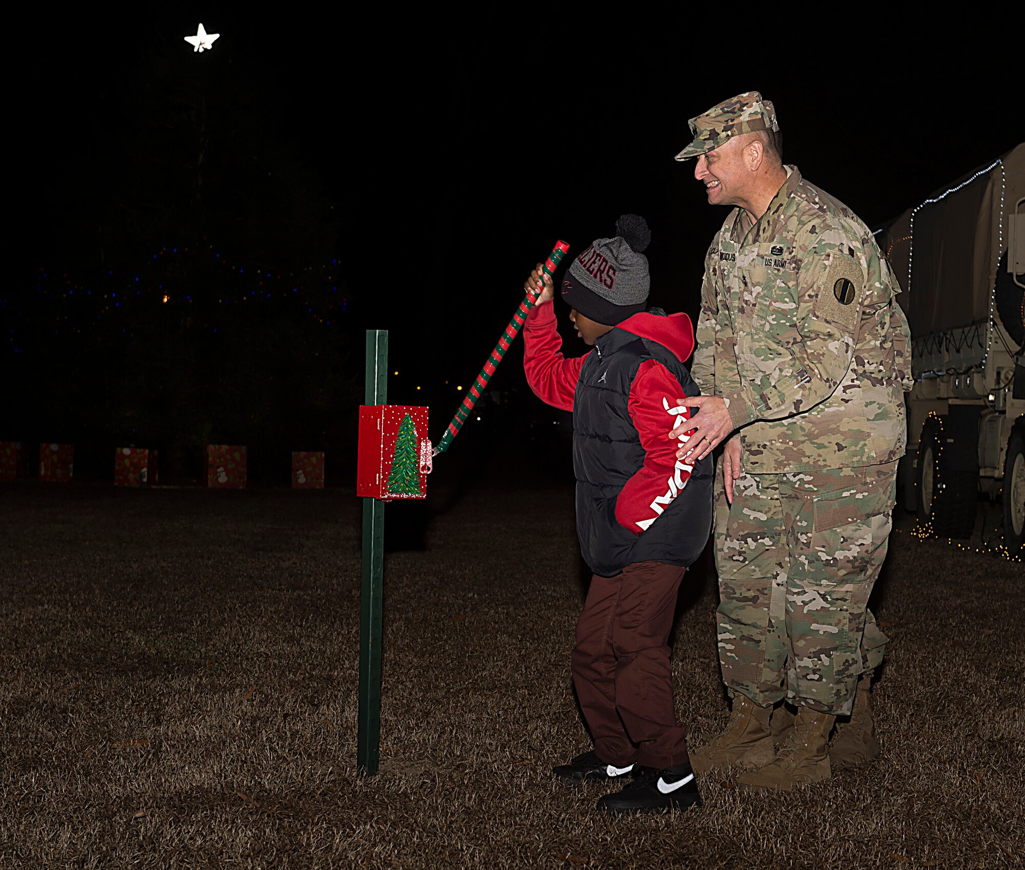 U.S. Army Maj. Gen. Anthony Funkhouser, U.S. Army Training and Doctrine Command Center for Initial Military Training commander, and Jamarkus Cheathem, age 7, son of U.S. Army Sgt. Mark Cheathem, 7th Transportation Brigade (Expeditionary) squad leader, flip the switch to light the tree during the 61st annual Holiday Tree Lighting celebration at Joint Base Langley-Eustis, Va., Dec. 2, 2016. The event included carolers singing “We Wish You a Merry Christmas”, “Jingle Bells” and “Here Comes Santa Claus.” (U.S. Air Force photo by Airman 1st Class Derek Seifert)