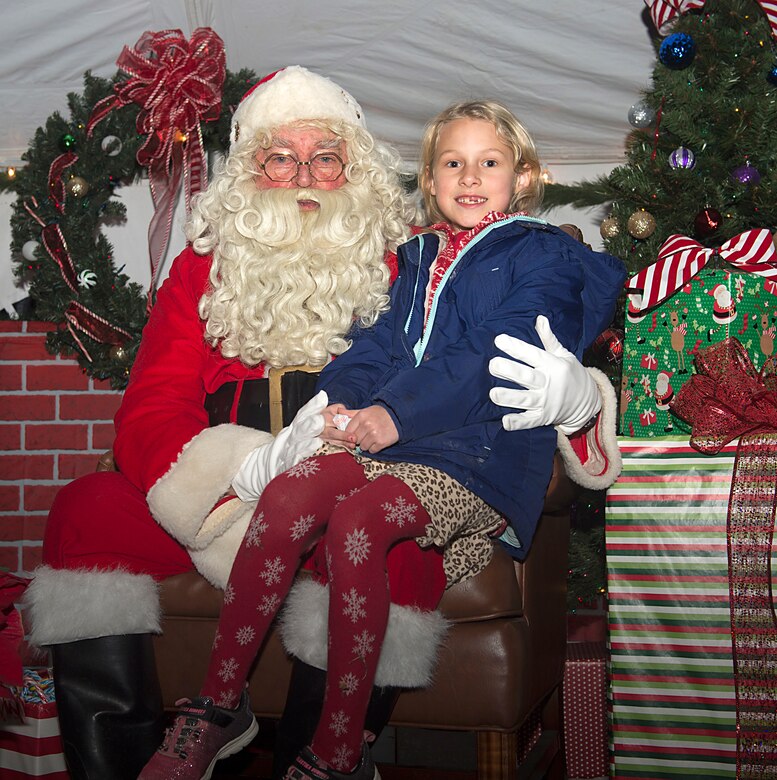 Santa sits with Anna Livingood-Fry, age 7, daughter of U.S. Army Lt. Col. Lisa Livingood, U.S. Army Training and Doctrine Command Strategic Policy and Plans deputy, during the 61st annual Holiday Tree Lighting celebration at Joint Base Langley-Eustis, Va., Dec. 2, 2016. Ft. Eustis first hosted the holiday tree lighting ceremony in 1955. (U.S. Air Force photo by Airman 1st Class Derek Seifert)