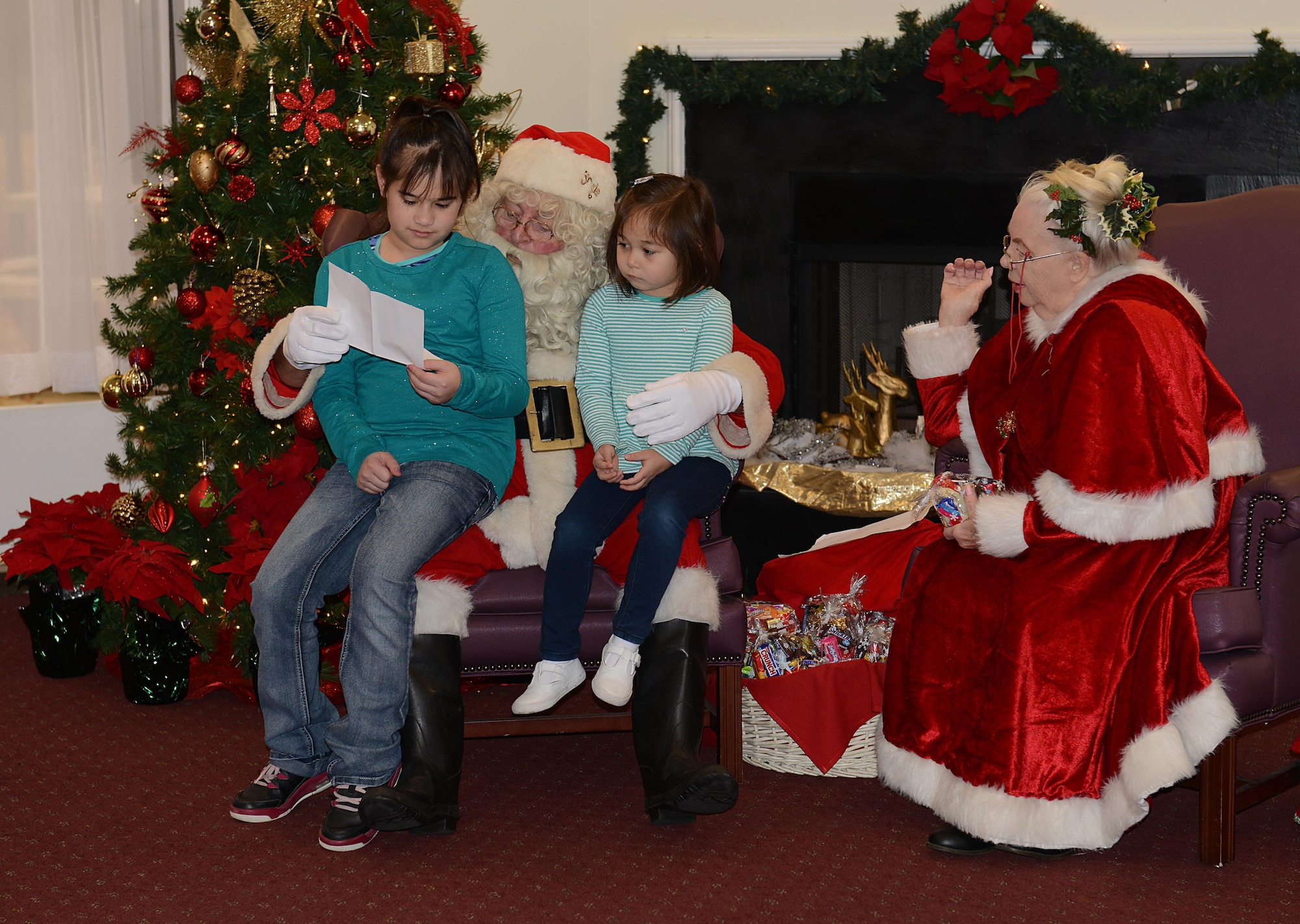 Santa and Mrs. Claus read wish lists from McKenzie Santos, age 11, and Ashlyn Santos, age 5, daughters  of U.S. Army Sgt. 1st Class Alberto Santos, U.S. Army Training and Doctrine Command Center for Initial Military Training medical specialist, during the brunch with Santa event at Joint Base Langley-Eustis, Va., Dec. 4, 2016. U.S. service members and their families met with Santa and Mrs. Claus, took photos and ate at a buffet during the event. (U.S. Air Force photo by Staff Sgt. Teresa J. Cleveland)