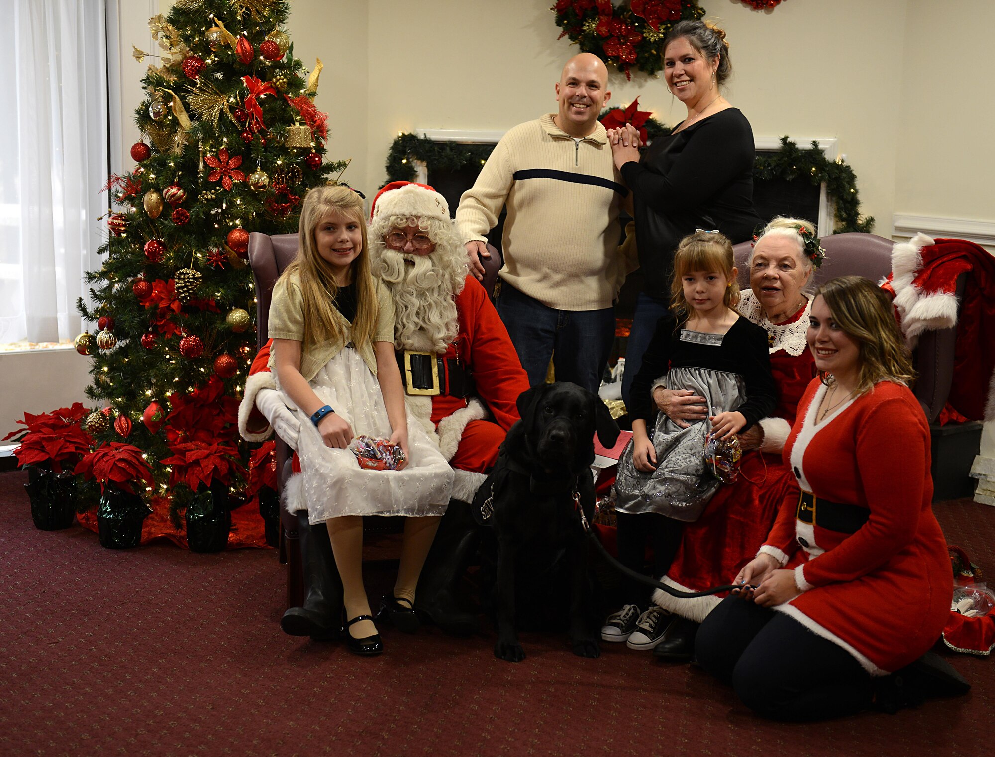 U.S. Army Sgt. Matt Johns, 221st Military Police Detachment officer, his family and his daughter’s service dog, Hope, take a photo with Santa and Mrs. Claus during the brunch with Santa event at Joint Base Langley-Eustis, Va., Dec. 4, 2016. Each year, Santa and Mrs. Claus take time out of their holiday schedule to meet with children at various events on the installation. (U.S. Air Force photo by Staff Sgt. Teresa J. Cleveland)