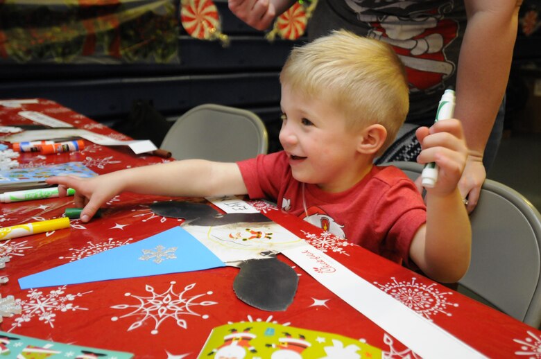 Mason Taykowski enjoys a crafts booth during the 2016 Candy Land Children’s Holiday Fest at Schriever Air Force Base, Colorado, Saturday, Dec. 3, 2016. More than 53 volunteers set up and manned stations for the festival. (U.S. Air Force photo/1st Lt. Darren Domingo)