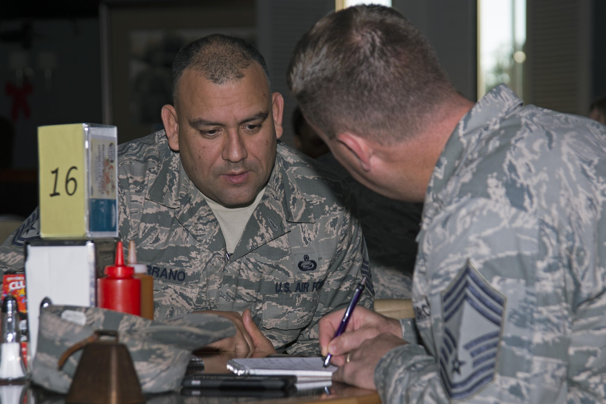 U.S. Air Force Senior Master Sgt. Luis Serrano, 20th Force Support Squadron superintendent, left, provides Chief Master Sgt. Steven Mullens, 20th Mission Support Group superintendent, right, his work information during a speed networking event at Shaw Air Force Base, S.C., Dec. 1, 2016. Senior NCOs attending the event collected contact information from individuals they met, creating a personal resource guide. (U.S. Air Force photo by Airman 1st Class Kathryn R.C. Reaves)