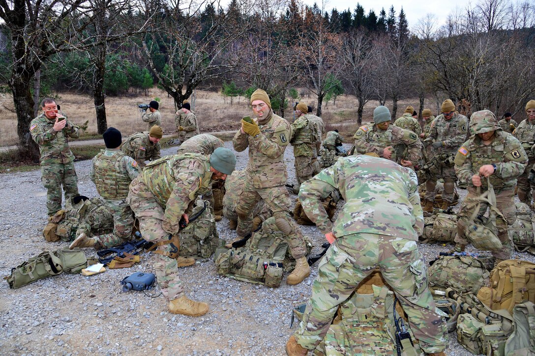 Soldiers apply camouflage paint before participating in a live-fire exercise during Exercise Mountain Shock at Pocek Range in Slovenia, Dec. 5, 2016. U.S. and Slovenian forces participated in the emergency response deployment exercise, which focuses on rapid deployment and team cohesion with weapon systems tactics and procedures. The soldiers are paratroopers assigned to 1st Squadron, 91st Cavalry Regiment. Army photo by Davide Dalla Massara