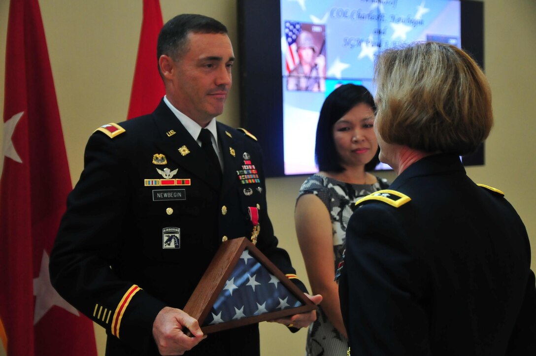 Col. Charles E. Newbegin is presented with a U.S. Flag July 22, 2016 at Marshall Hall, Fort Bragg, N.C. as part of a retirement celebration for him and Sgt. Maj. Paul J. Klikas.(U.S. Army photo by Pfc. Hubert D Delany III)