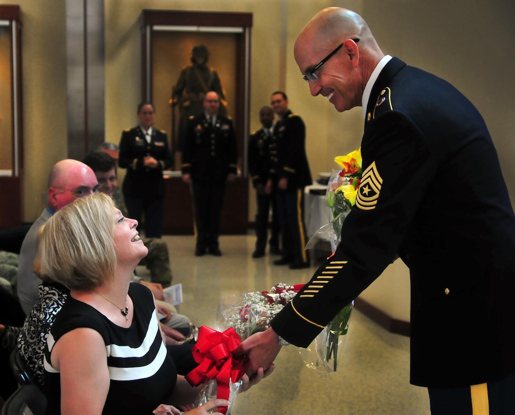 Sgt. Maj. Paul J. Klikas gives his wife flowers July 22, 2016, at Marshall Hall, Fort Bragg, N.C. as part of a retirement celebration for Col. Charles E. Newbegin and himself. (U.S. Army photo by Pfc. Hubert D Delany III)