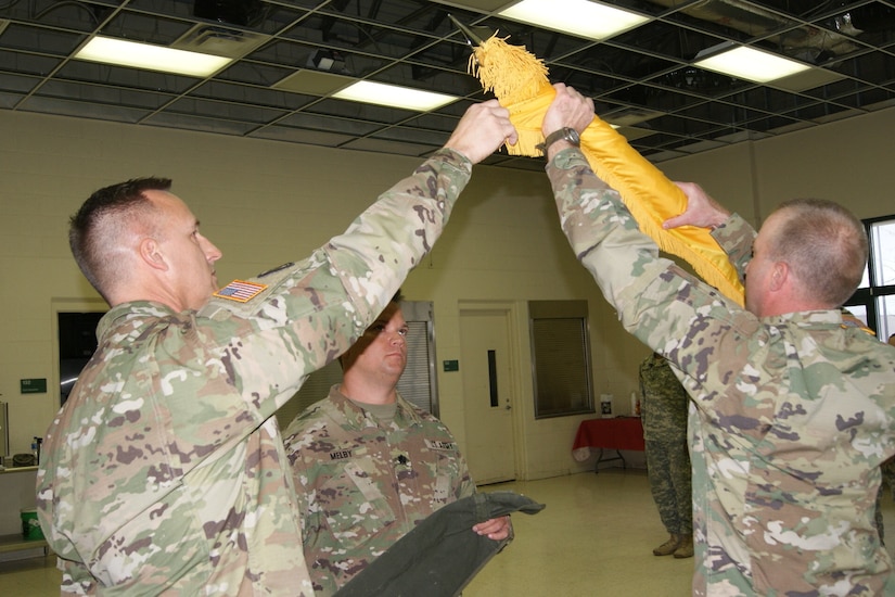 (Left) The 800th Logistics Support Brigade Commander Col. Bradly Boganowski and 1st Sgt. Michael Olson, acting command sergeant major of the 3rd Battalion, 399th Regiment, (right) furl the flag at the battalion's deactivation ceremony as Lt. Col. Ryan Melby, 3rd Battalion commander, (center) waits to encase the flag. The ceremony was held at the Army Reserve Center in Sturtevant, Wis., Dec. 3, 2016.