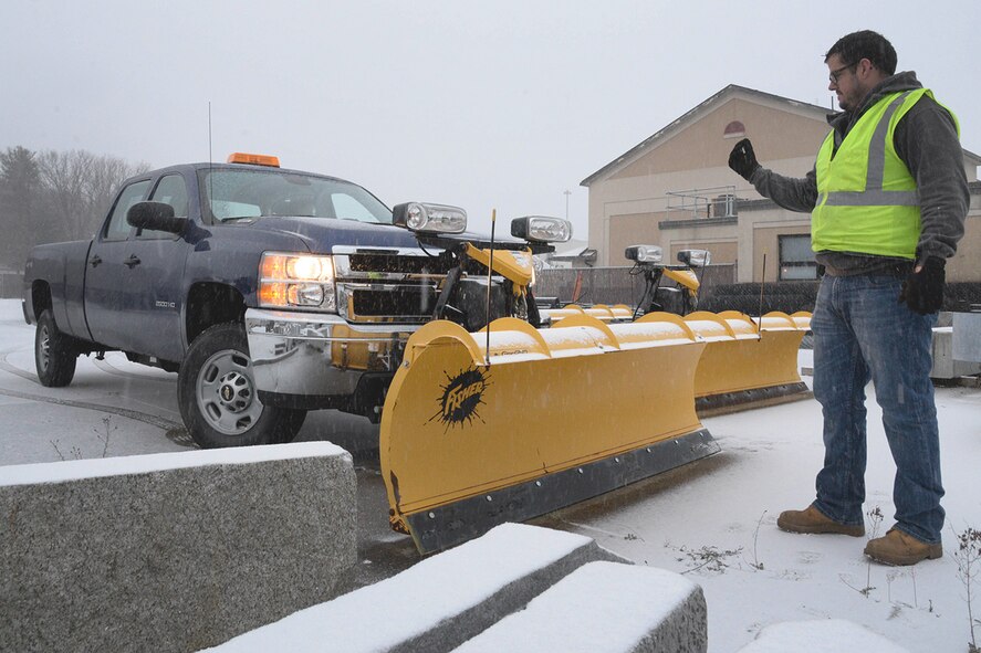 James J. Marrott, 66th Civil Engineering Division laborer, guides a vehicle into position to attach a snow plow in the civil engineering complex Dec. 5. CE is responsible for snow and ice removal from base streets, sidewalks and parking areas. Base snow and ice removal, excluding housing, is accomplished by a four-tiered priority system as identified in the 66th Air Base Group Snow and Ice Control Plan. For further information, visit http://www.hanscom.af.mil/About-Us/Fact-Sheets/Display/Article/379477/making-plans-for-winter-weather. (U.S. Air Force photo by Linda LaBonte Britt)