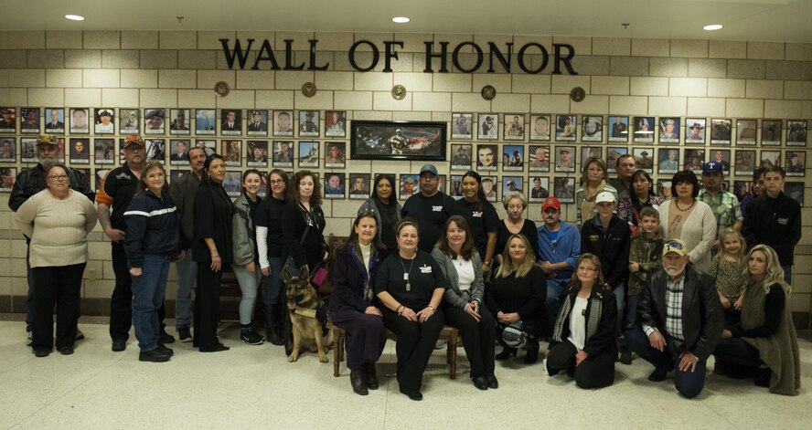 Members of Surviving Families of Fallen Warriors, a local organization for families who have lost loved ones during their time of military service, gather in front of the newly established Wall of Honor at Dyess Air Force Base, Texas, Dec. 3, 2016. The wall, which is located in the Armed Forces Reserve Center, currently displays more than 100 photos from members in 90 counties across Texas. (U.S. Air Force photo by Airman 1st Class Katherine Miller)