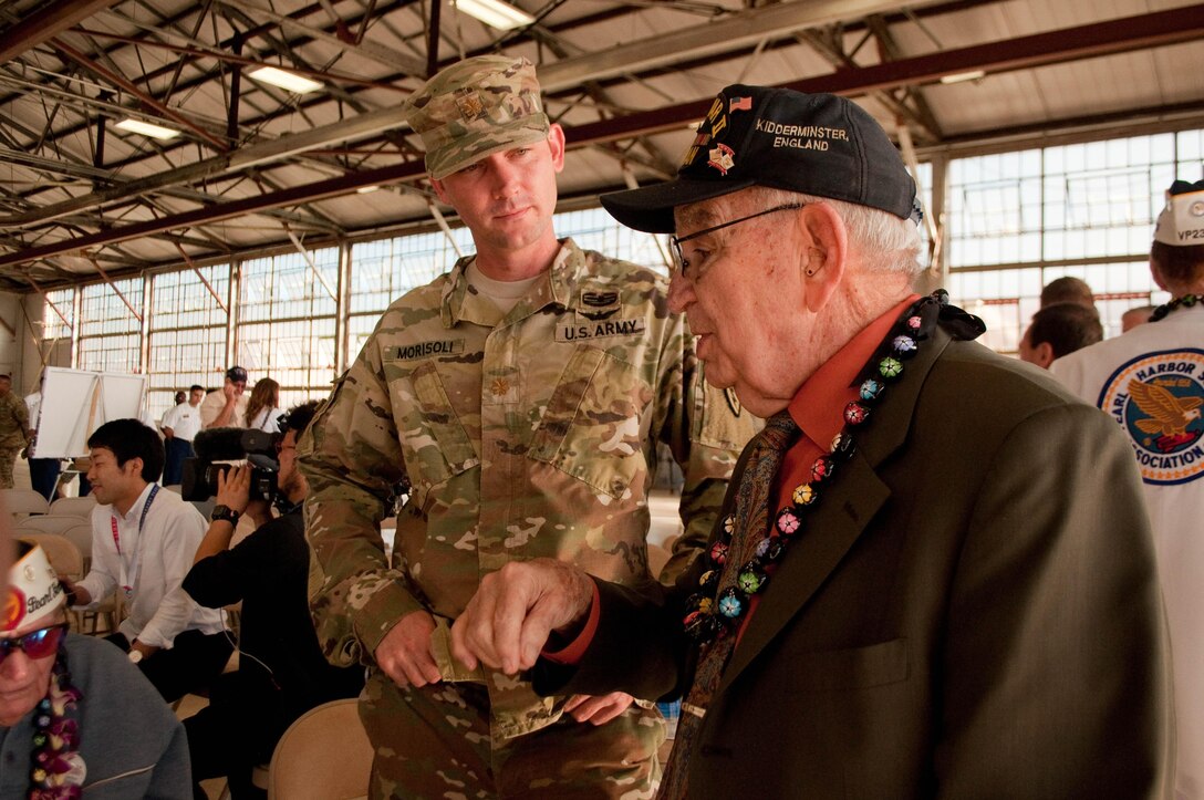 Army Maj. Chris Morisoli, left, talks with World War II veteran Peter B. DuPré, after the Wheeler Field Remembrance, in Hangar 206 at Wheeler Army Airfield, Hawaii, Dec. 5, 2016. Morisoli is a member of the 25th Infantry Division based in Hawaii. Army photo by Kristen Wong