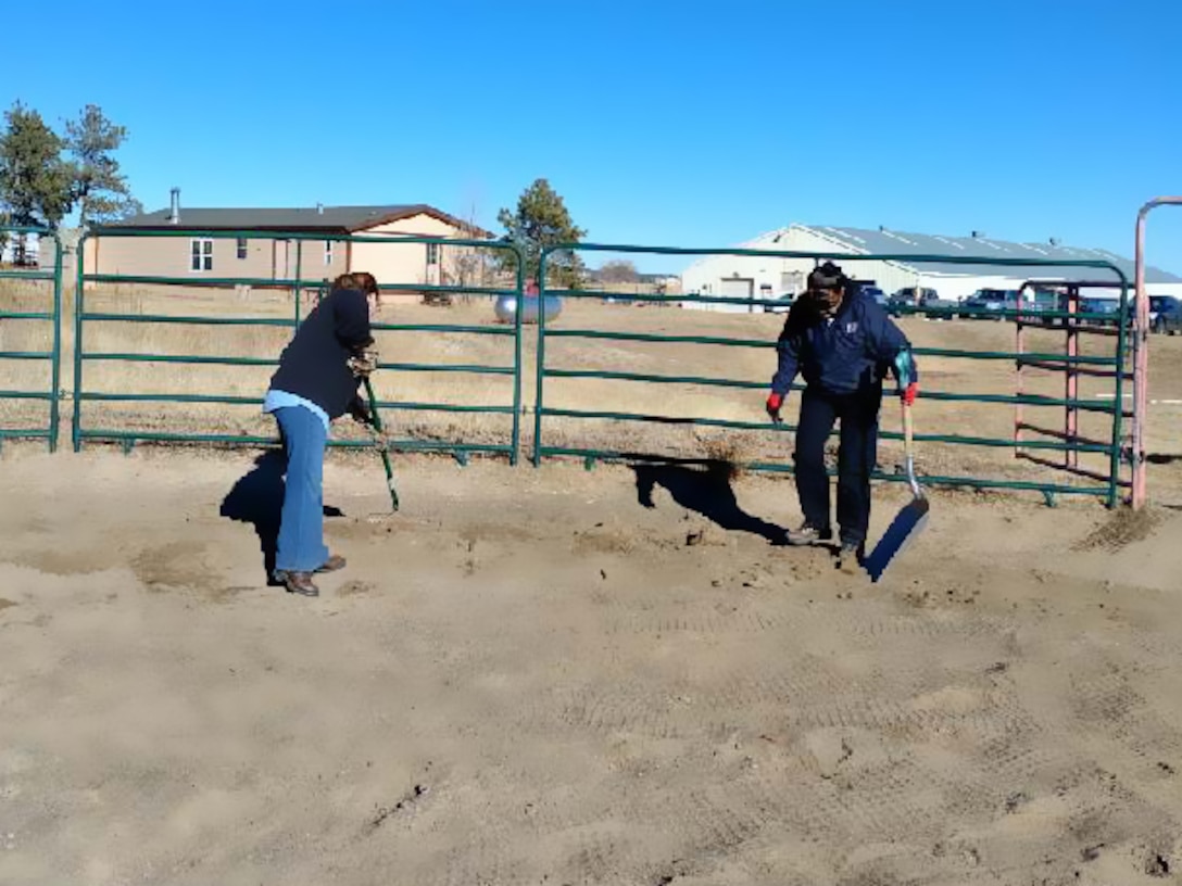 Senior Master Sgt. Tiffany Maine and Senior Master Sgt. Sonia Balas, both of HQ RIO Detachment 3, spread fresh dirt on an outdoor riding coral at the Pikes Peak Therapeutic Riding Center, Nov. 30. The Detachment 3 staff spent the afternoon doing variety of maintenance and housekeeping projects for the non-profit.