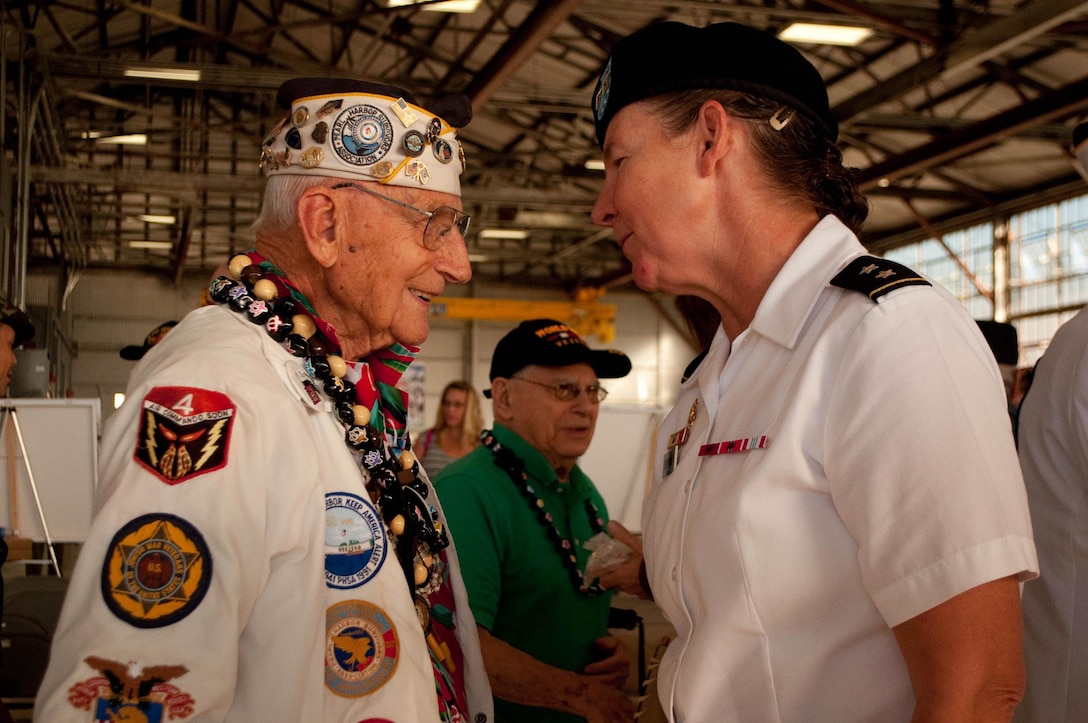 Army Maj. Gen. Susan Davidson, commander, 8th Theater Sustainment Command, Hawaii, talks with World War II veteran Stuart Hedley after the Wheeler Field Remembrance, in Hangar 206 at Wheeler Army Air Field, Hawaii, Dec. 5, 2016. Army photo by Kristen Wong