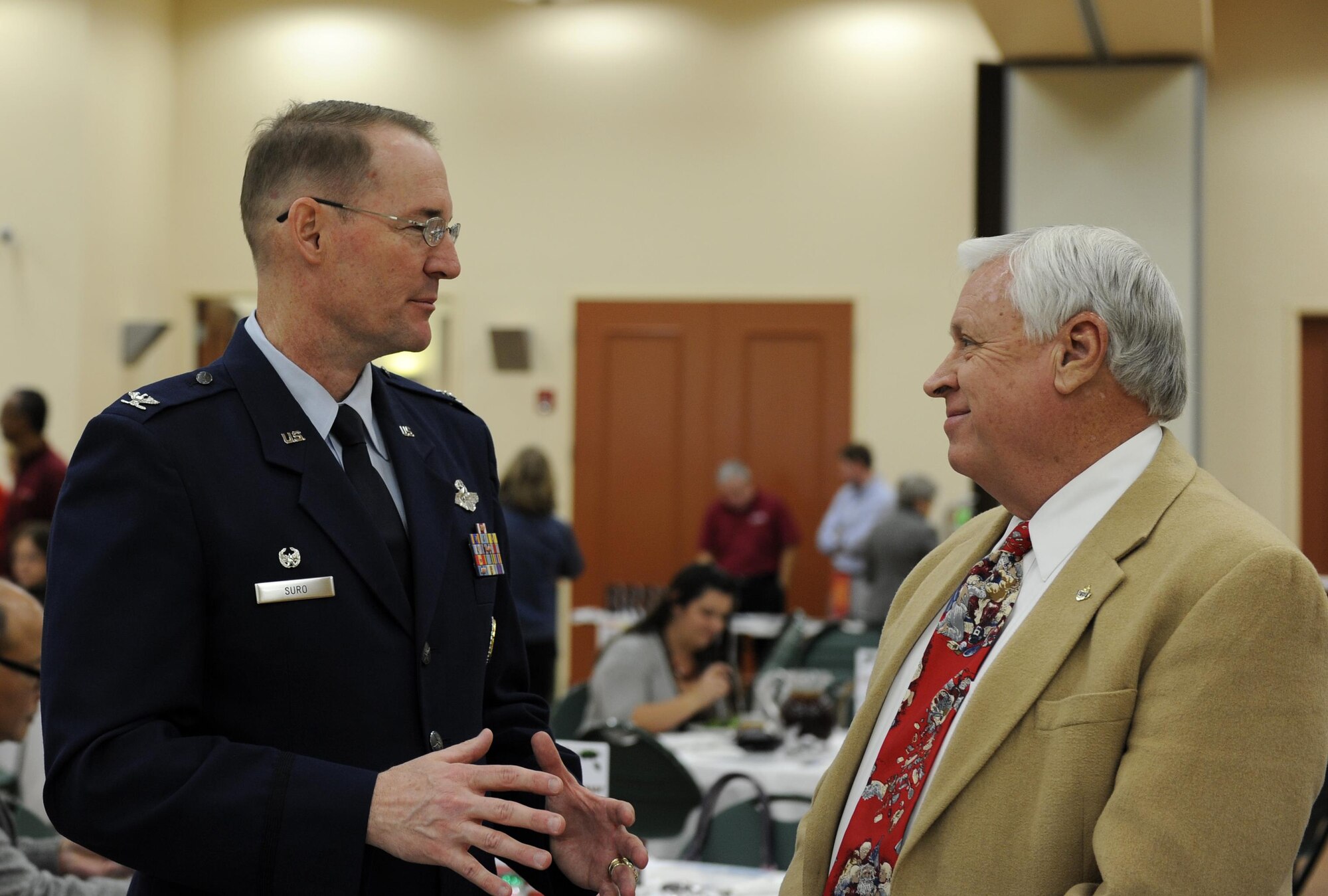 Col. Roger Suro, 340th Flying Training Group commander, speaks with Dr. Jim Antenen, Wayland Baptist University dean, during the Chamber of Schertz-Cibolo-Selma monthly Military Affairs Committee luncheon at the Schertz Civic Center in Schertz, Texas, Dec. 6. Col. Suro was recognized as the Chamber’s “Hidden Hero” for December. The 340 FTG, located at Joint Base San Antonio-Randolph, Texas, supports Air Education and Training Command’s specialized undergraduate pilot training, joint primary pilot training, pilot instructor training, introduction to fighter fundamentals, Euro-NATO joint jet pilot training, basic military training and the Air Force Academy’s Airmanship Programs. The 340th FTG is the largest flying group in the Air Force, consisting of 425 instructor pilots assigned to six squadrons. Instructors fly a variety of aircraft, including the T-1A Jayhawk, T-6A Texan II, T-38 Talon,T-41A Mescalero, T-51A, T-52A, T-53, TG-15/TG-16 gliders, and UV-18B Twin Otter. There are openings with the 340th for traditional Reserve and active Guard and Reserve instructor pilots and jumpmasters. (Air Force photo by Tech. Sgt. Ave Young, 502nd Air Base Wing Public Affairs).