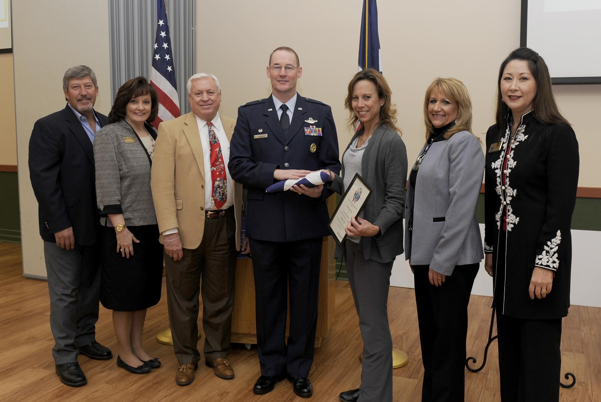 Col. Roger Suro (center), 340th Flying Training Group commander, receives a Texas state flag that was flown over the state capital building in Austin, Texas, from members of the Schertz-Cibolo-Selma Chamber during the chamber’s monthly luncheon Dec. 6, at the Schertz-Civic Center in Schertz, Texas. Chamber members joining Suro in the photo are (L to R): Retired Chief Master Sgt. Tim Brown, Schertz-Cibolo-Selma Military Affairs Committee member, Kathleen Shortland, Military Affairs Committee chairman elect, Dr. Jim Antenen, Wayland Baptist University dean, Kelly Folis, Texas State Senator Donna Campbell’s constituent outreach coordinator, Jill Gridley-Carpenter, Broadway Bank and Maggie Titterington, chamber president. Every month the Chamber sponsors a military member to be recognized as a Hidden Hero. The 340 FTG, located at Joint Base San Antonio-Randolph, Texas, supports Air Education and Training Command’s specialized undergraduate pilot training, joint primary pilot training, pilot instructor training, introduction to fighter fundamentals, Euro-NATO joint jet pilot training, basic military training and the Air Force Academy’s Airmanship Programs. The 340th FTG is the largest flying group in the Air Force, consisting of 425 instructor pilots assigned to six squadrons. Instructors fly a variety of aircraft, including the T-1A Jayhawk, T-6A Texan II, T-38 Talon, T-41A Mescalero, T-51A, T-52A, T-53, TG-15/TG-16 gliders, and UV-18B Twin Otter. There are openings with the 340th for traditional Reserve and active Guard and Reserve instructor pilots and jumpmasters. (Air Force photo by Tech. Sgt. Ave Young, 502nd Air Base Wing Public Affairs).