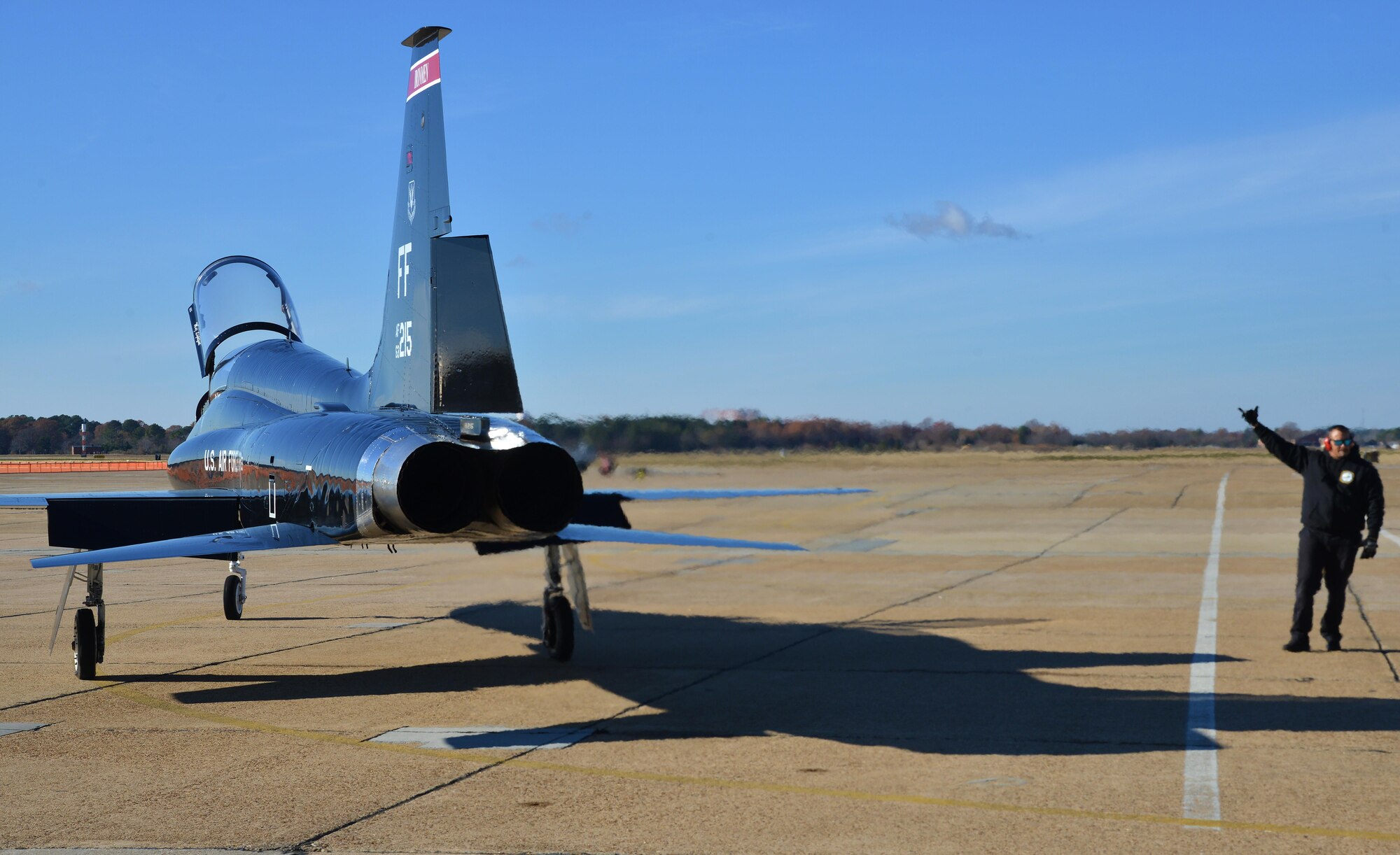 Orlando Vasquez, Mission 1st Support Services contractor, guides U.S. Air Force Capt. Chelsea Bailey, 71st Fighter Training Squadron T-38 Talon adversary air mission commander, down the runway at Joint Base Langley-Eustis, Va., Dec. 6, 2016. The T-38s are the adversaries when training in air-to-air combat with the F-22 Raptors. (U.S. Air Force photo by Airman 1st Class Tristan Biese)