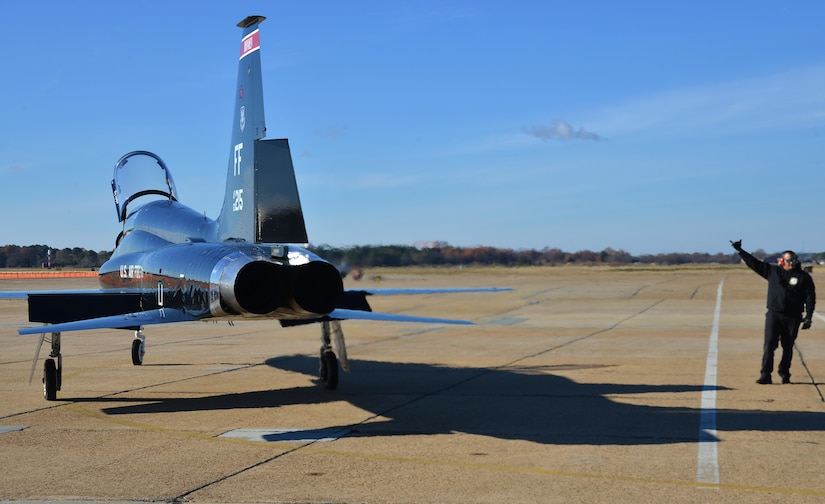 Orlando Vasquez, Mission 1st Support Services contractor, guides U.S. Air Force Capt. Chelsea Bailey, 71st Fighter Training Squadron T-38 Talon adversary air mission commander, down the runway at Joint Base Langley-Eustis, Va., Dec. 6, 2016. The T-38s are the adversaries when training in air-to-air combat with the F-22 Raptors. (U.S. Air Force photo by Airman 1st Class Tristan Biese)