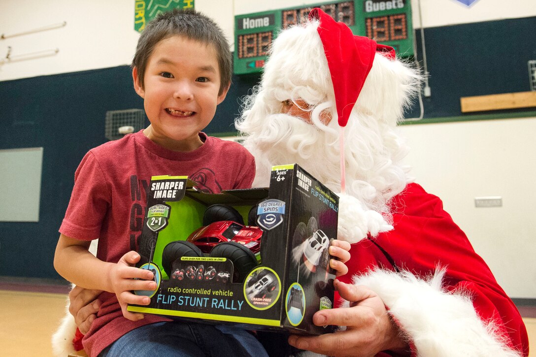 A young boy smiles after receiving a present from Santa Claus during Toys for Tots at Deering School in Deering, Alaska, Nov. 30, 2016. Santa was assisted by Marine Corps Capt. Michael Sickels, assigned to Detachment Delta, 4th Law Enforcement Battalion. Air Force photo by Alejandro Pena