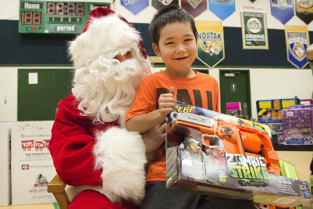 A young boy smiles after receiving a present from Santa Claus during Toys for Tots at Deering School in Deering, Alaska, Nov. 30, 2016. Santa was assisted by Marine Corps Capt. Michael Sickels, assigned to Detachment Delta, 4th Law Enforcement Battalion. Air Force photo by Alejandro Pena