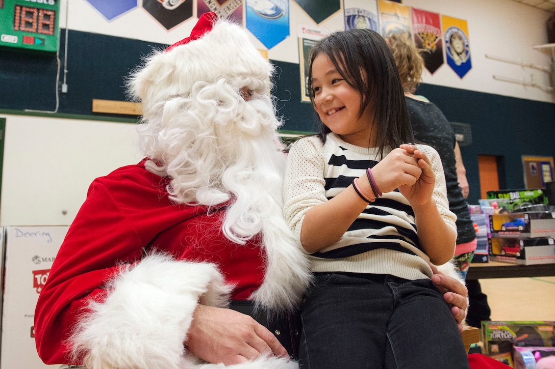 Santa Claus interacts with a child while passing out holiday presents during Toys for Tots at Deering School in Deering, Alaska, Nov. 30, 2016. Santa was assisted by Marine Corps Capt. Michael Sickels, assigned to Detachment Delta, 4th Law Enforcement Battalion. Air Force photo by Alejandro Pena