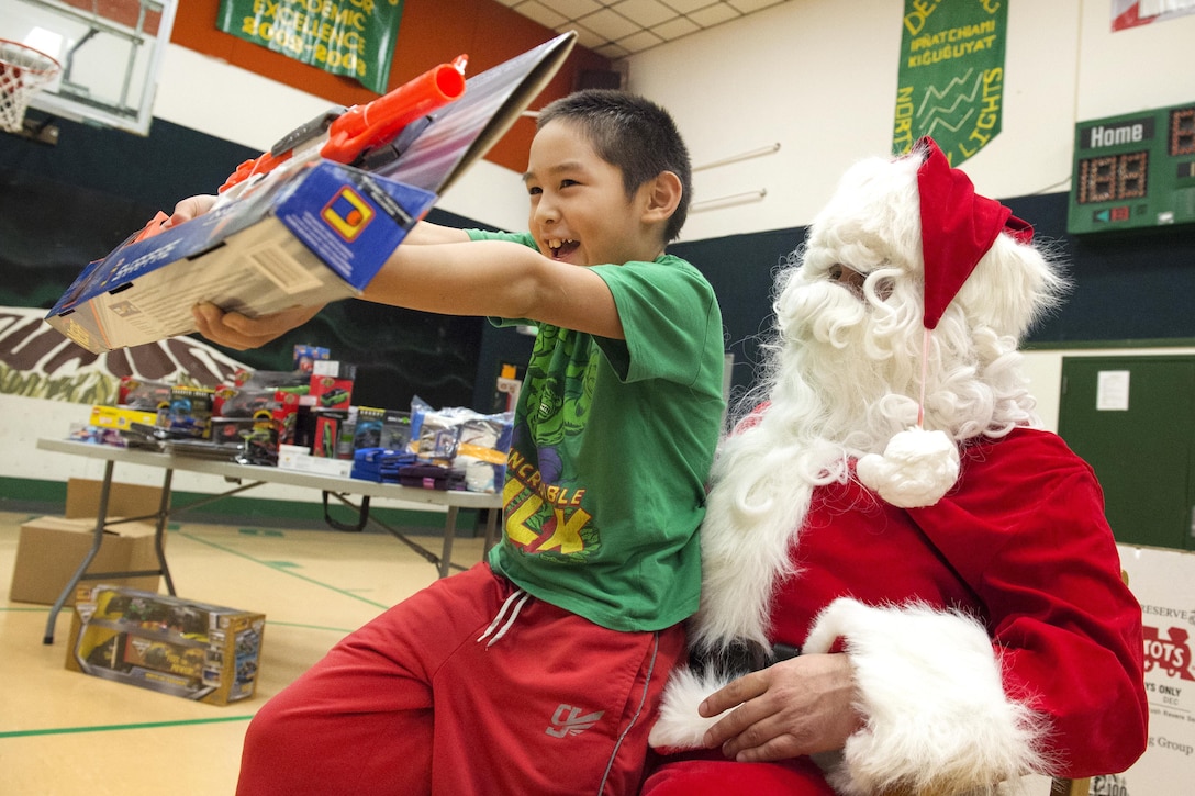 A young boy shows off his new toy after receiving the present from Santa Claus during Toys for Tots at Deering School in Deering, Alaska, Nov. 30, 2016. Santa was assisted by Marine Corps Capt. Michael Sickels, assigned to Detachment Delta, 4th Law Enforcement Battalion. Air Force photo by Alejandro Pena