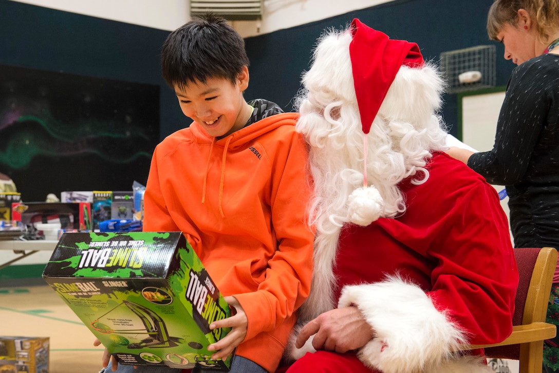A young boy reacts joyfully showing off his new toy after receiving the present from Santa Claus during Toys for Tots at Deering School in Deering, Alaska, Nov. 30, 2016. Santa was assisted by Marine Corps Capt. Michael Sickels, assigned to Detachment Delta, 4th Law Enforcement Battalion. Air Force photo by Alejandro Pena
