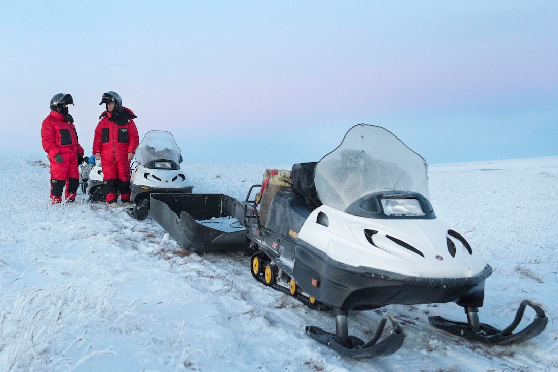 Marine Corps Capt. Michael Sickels, left, and 1st Sgt. Joshua Guffey, assigned to Detachment Delta, 4th Law Enforcement Battalion, pause to rest while traveling via snow machines from Deering to Kotzebue, Alaska, Dec. 1, 2016. Sickels and Guffey, assigned to Detachment Delta, 4th Law Enforcement Battalion, traveled in sub-zero temperatures to multiple villages in the Northwest Arctic borough to deliver holiday presents to Alaskan children as part of Toys for Tots. Air Force photo by Alejandro Pena