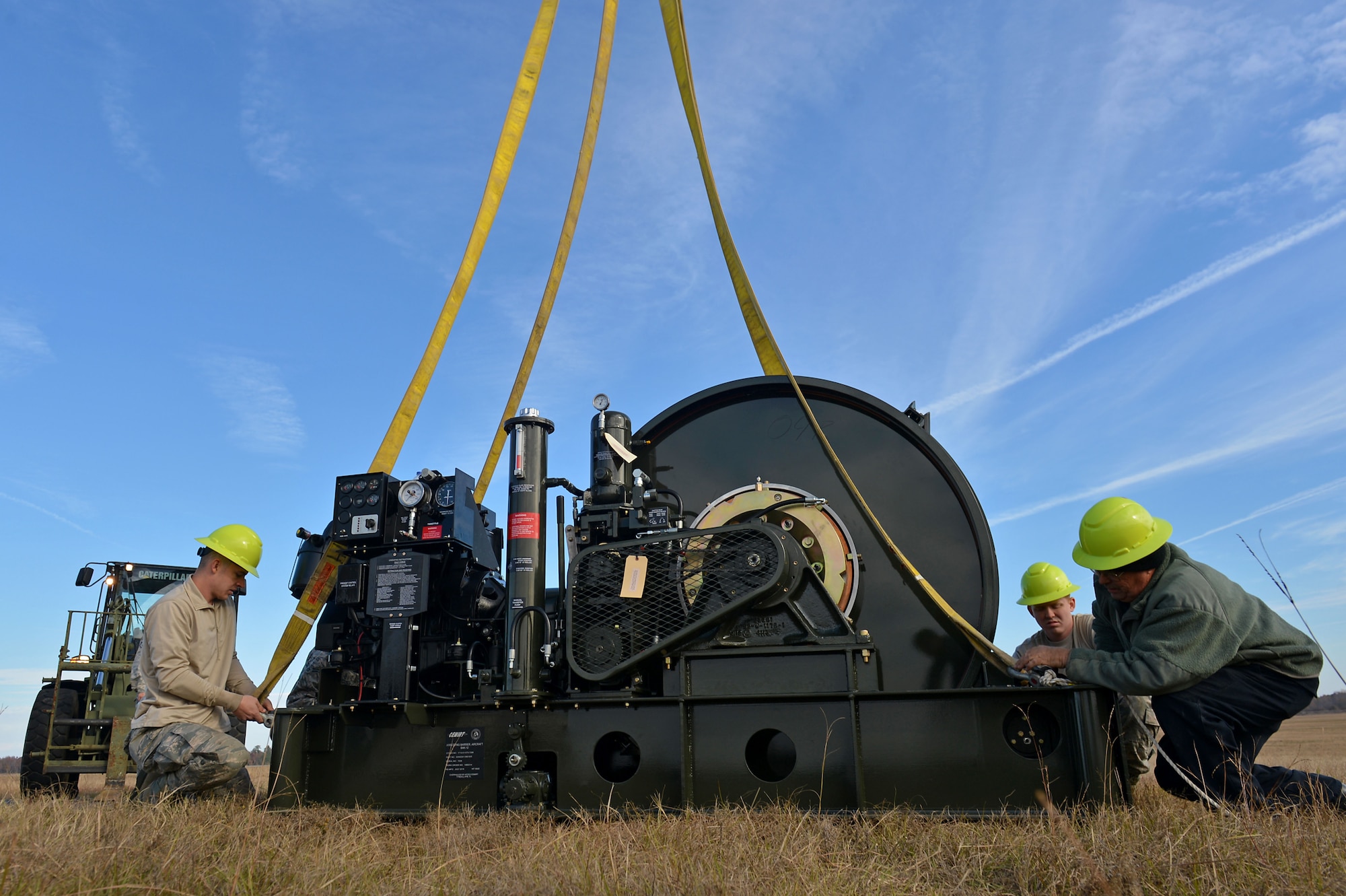 U.S. Airmen and contractors assigned to the 20th Civil Engineer Squadron power production flight perform the final check on a Barrier Artillery Kit-12 rotary friction brake aircraft arresting system at Shaw Air Force Base, S.C., Dec. 3, 2016. The newly installed arresting system is capable of withstanding a maximum of 65 million pounds of force when halting an aircraft. (U.S. Air Force photo by Airman 1st Class Christopher Maldonado)