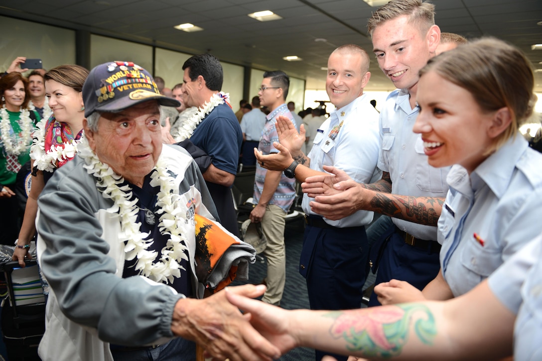 A World War II veteran shakes hands with service members at the Honolulu International Airport, Dec. 3, 2016. Coast Guard photo by Petty Officer 2nd Class Tara Molle