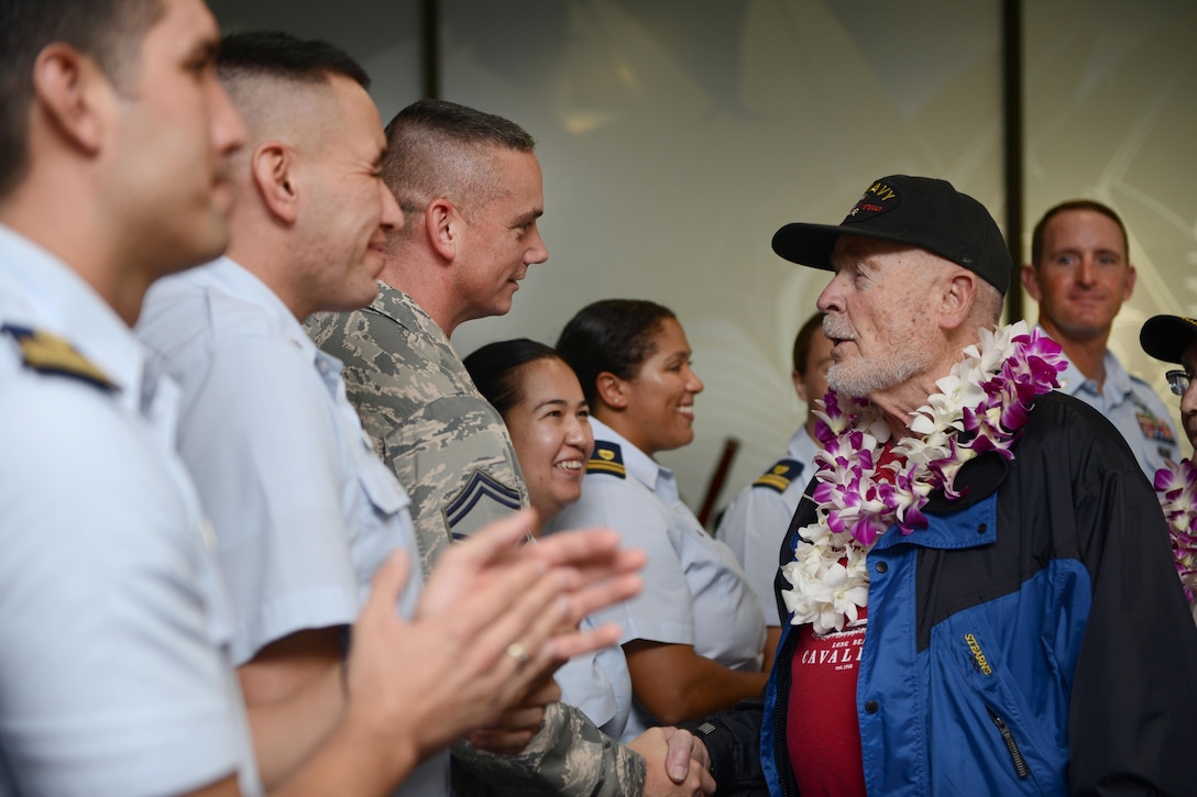 A World War II Navy veteran shakes hands with service members at the Honolulu International Airport, Dec. 3, 2016. Coast Guard photo by Petty Officer 2nd Class Tara Molle